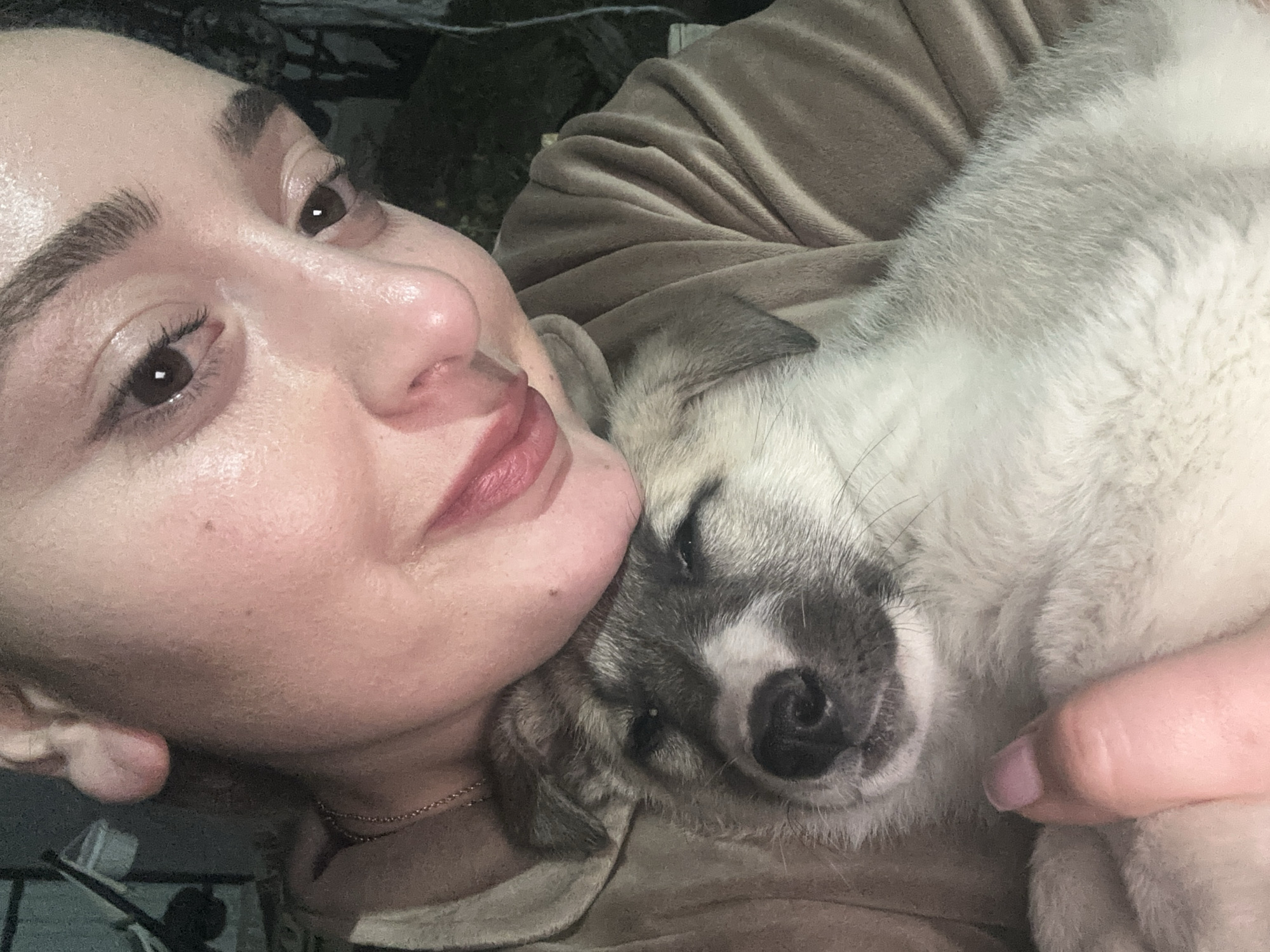 Woman tenderly holds puppy in affectionate moment in Georgia