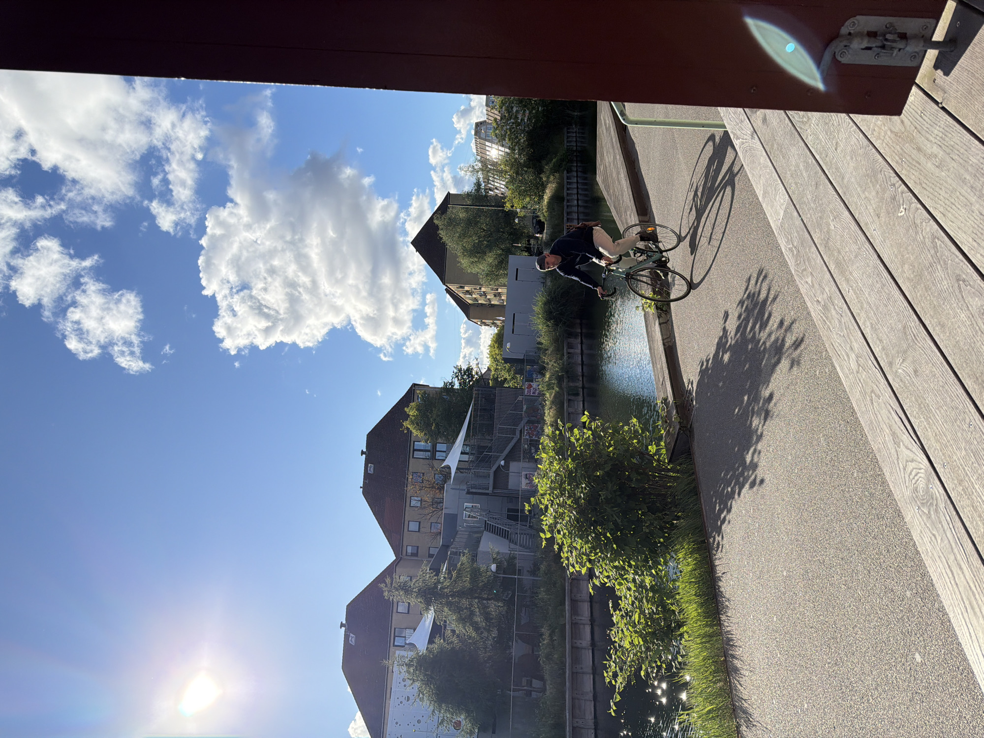Cycling along a sun-drenched canal path in Copenhagen