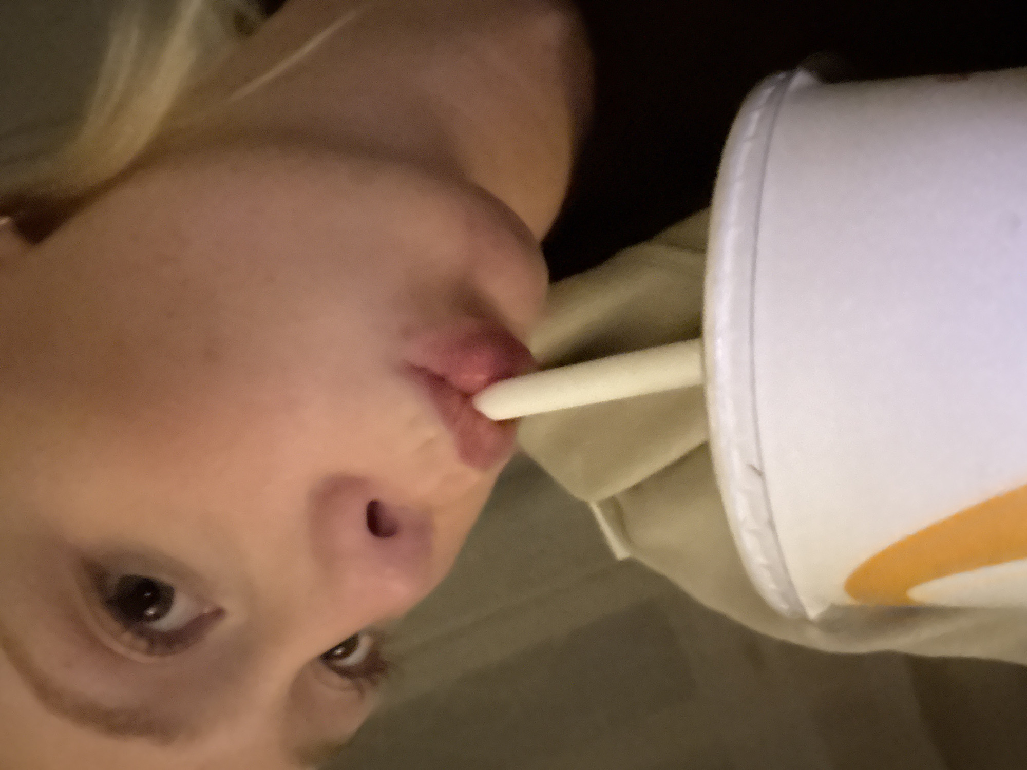 Person drinks from cup with straw in Tunbridge Wells