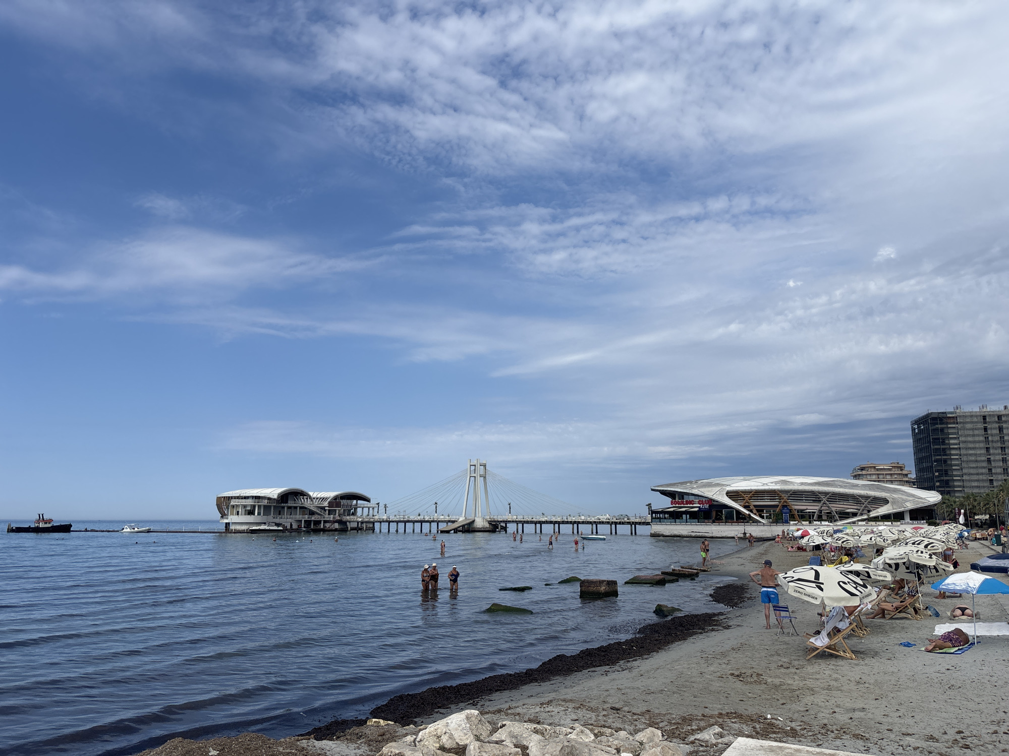 Sunny morning at Durrës beach, with a wet dog nearby.