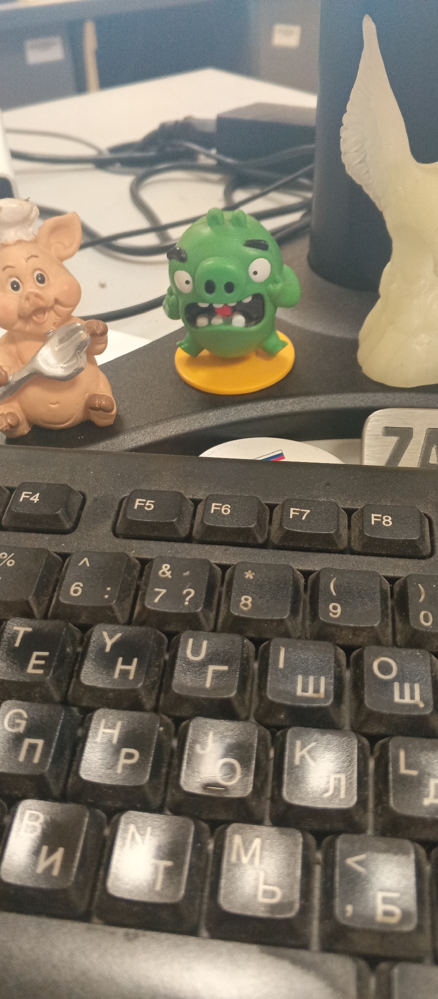 Cyrillic keyboard and desk trinkets hint at a Russian workspace
