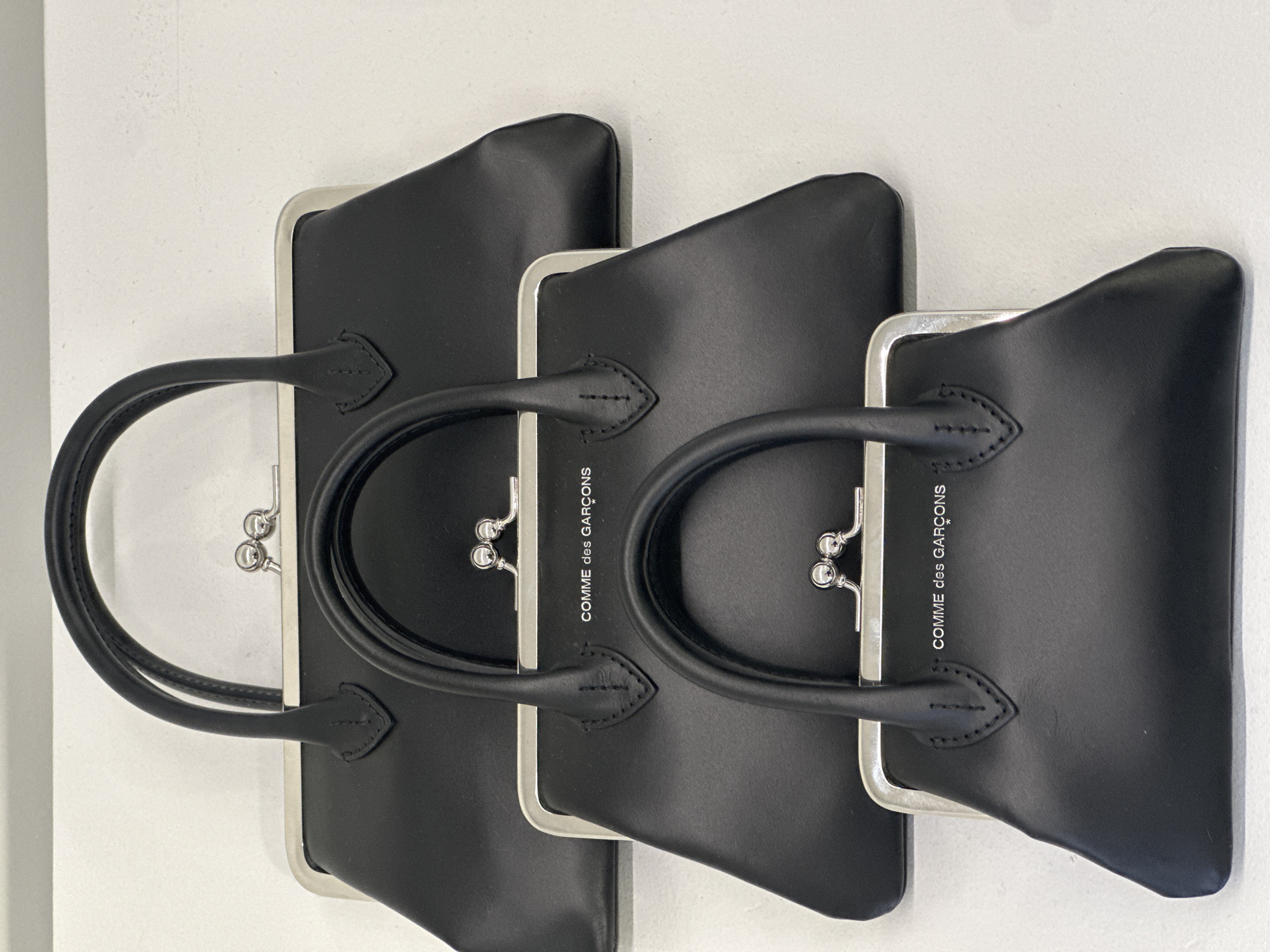 Three black handbags photographed in central London