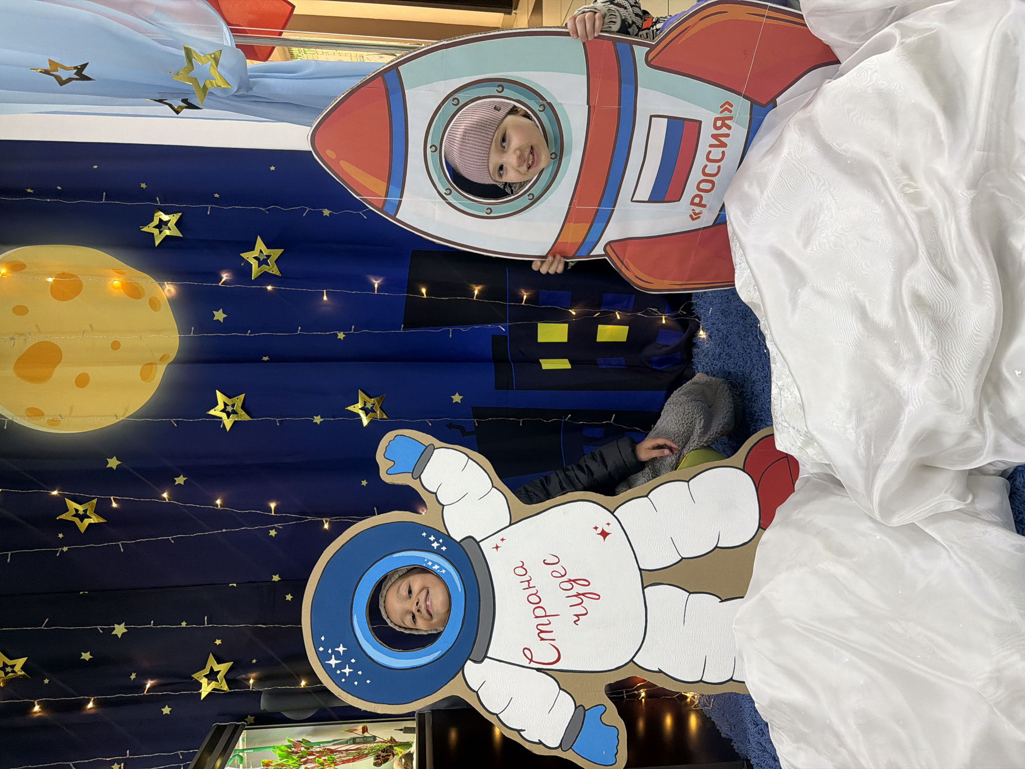 Children pose with space-themed cutouts in Krasnoyarsk