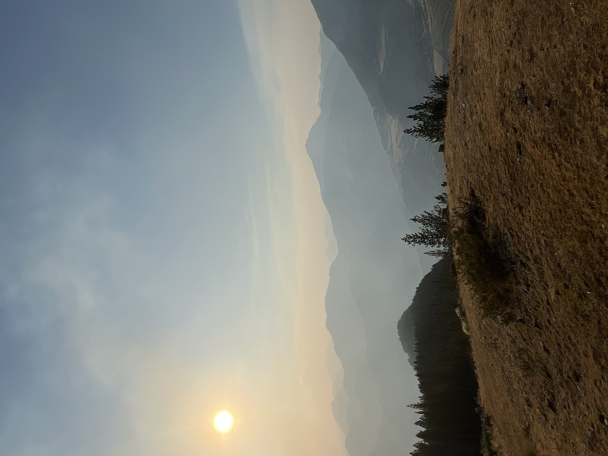 Hazy sunset over the Pyrenees, possible wildfire smoke in the air