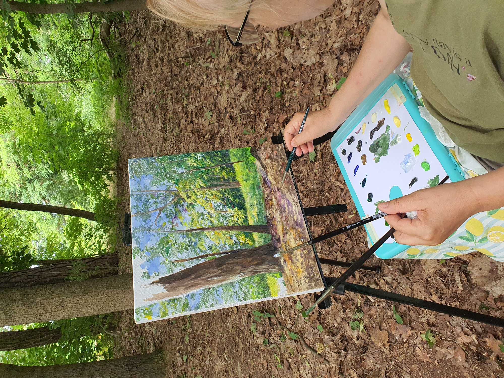 Plein air painting session along a forested path in Falkensee