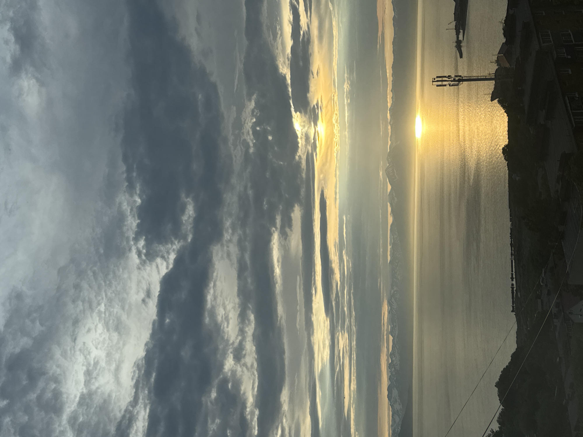 Stormy sunset over water with a mountainous horizon