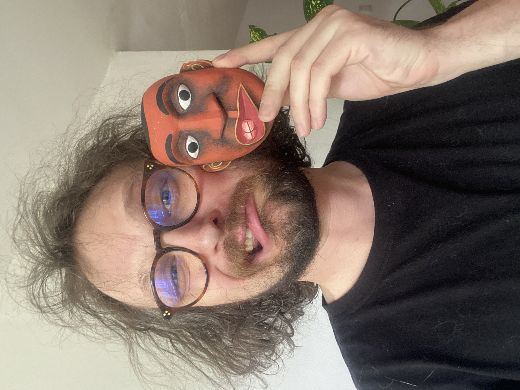 Person poses with decorative mask, personal items in Rusanovo