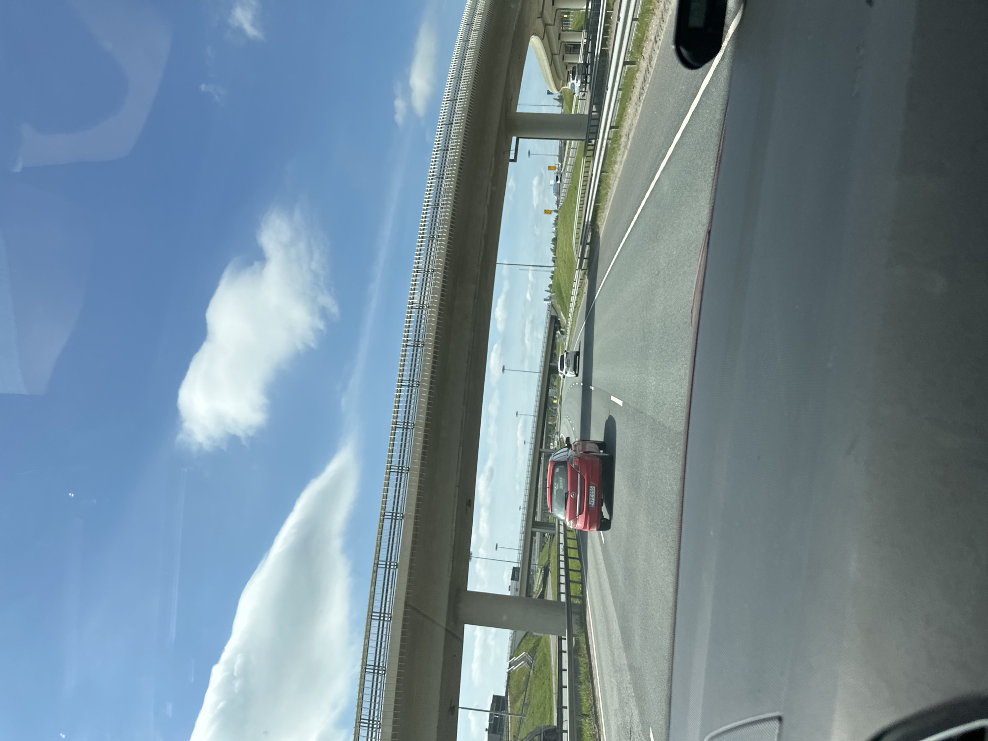 Highway drive past dealerships, pylons, and roadside landmarks