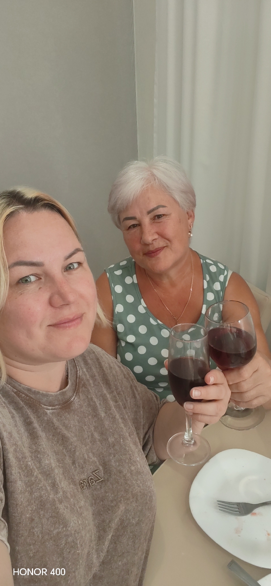Two women share wine in casual gathering, Izhevsk