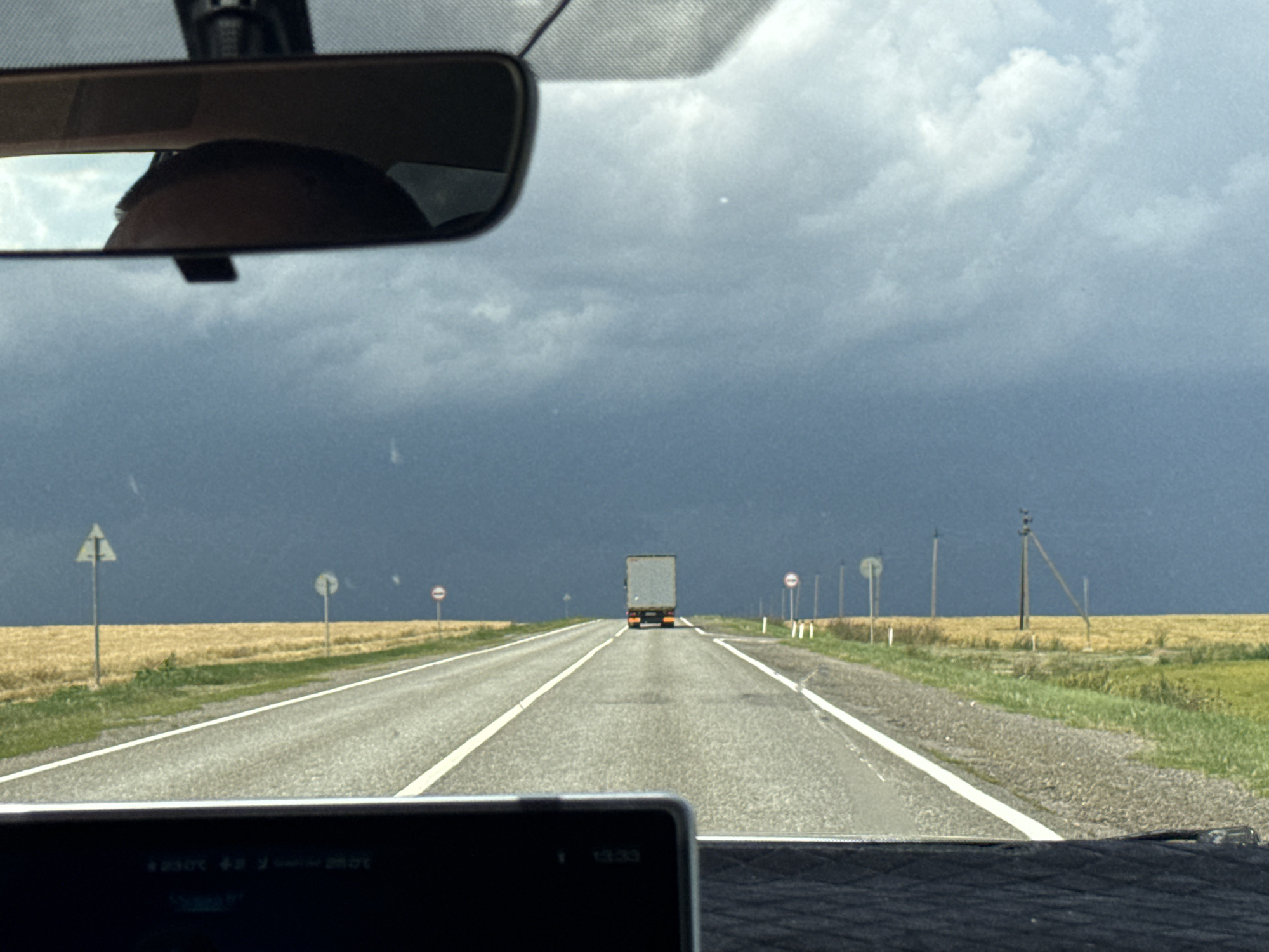 Road trip through Svetlograd farmland under dramatic summer skies