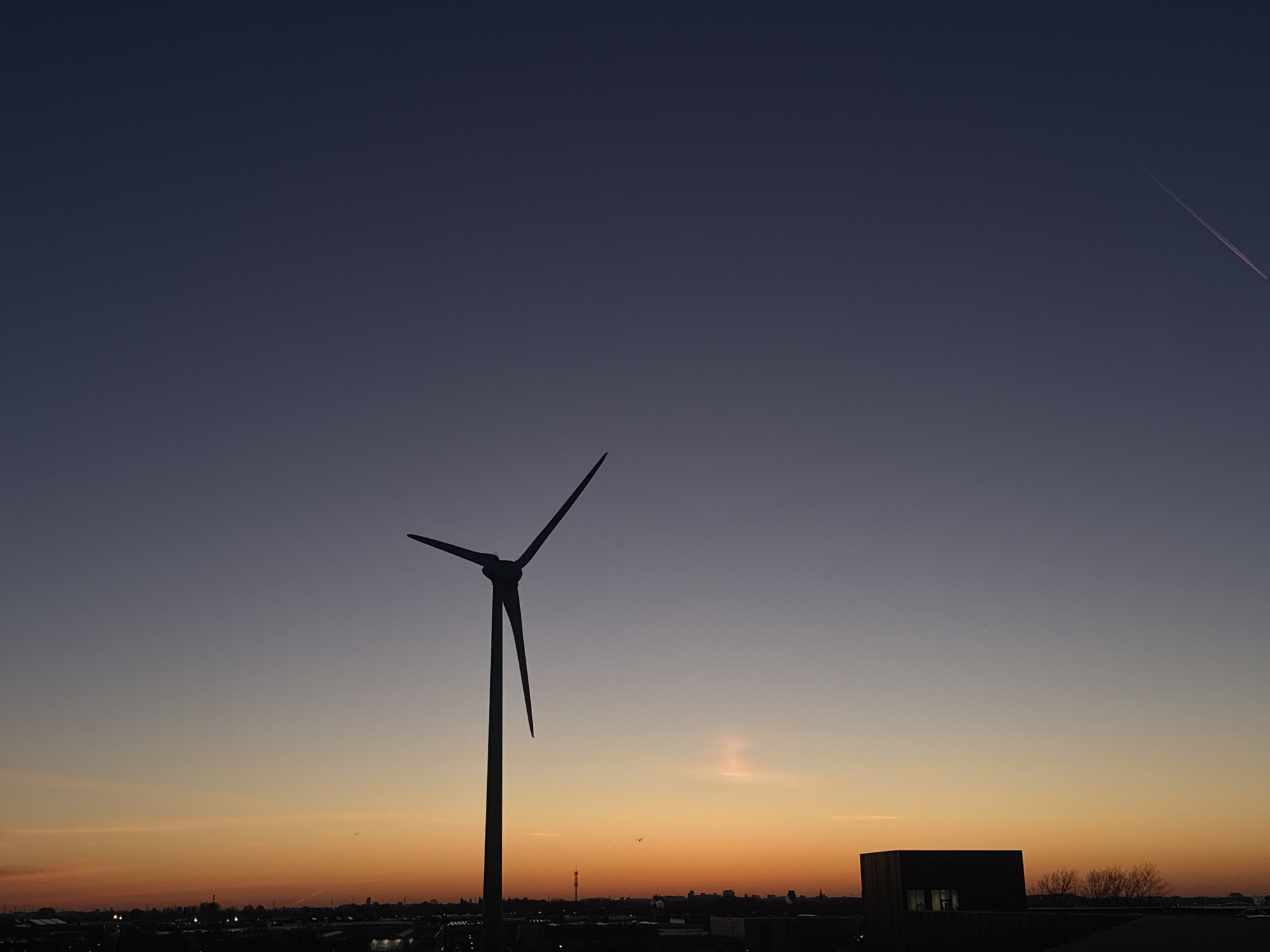 Wind turbine silhouetted against sunrise in Maasdijk, Netherlands