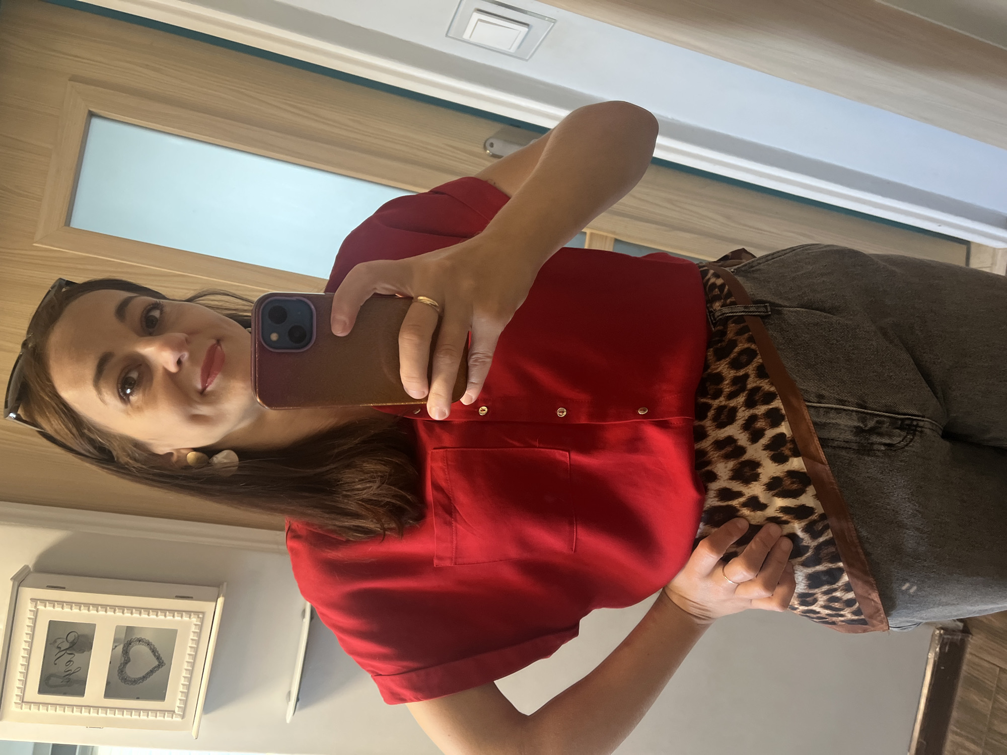 Mirror selfie in red shirt and leopard-print belt