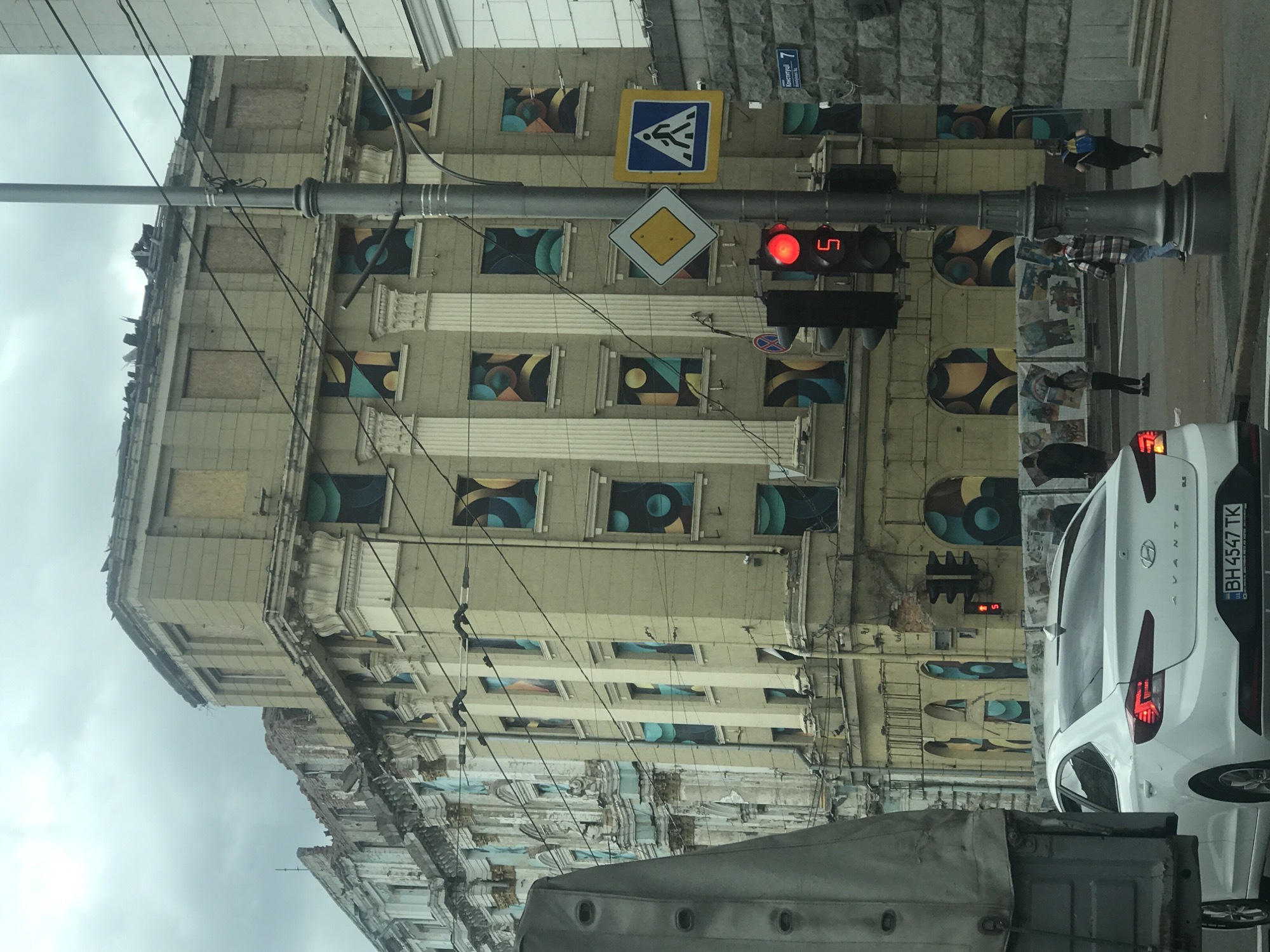 Art adorns damaged Kharkiv building as delivery cyclist navigates streets