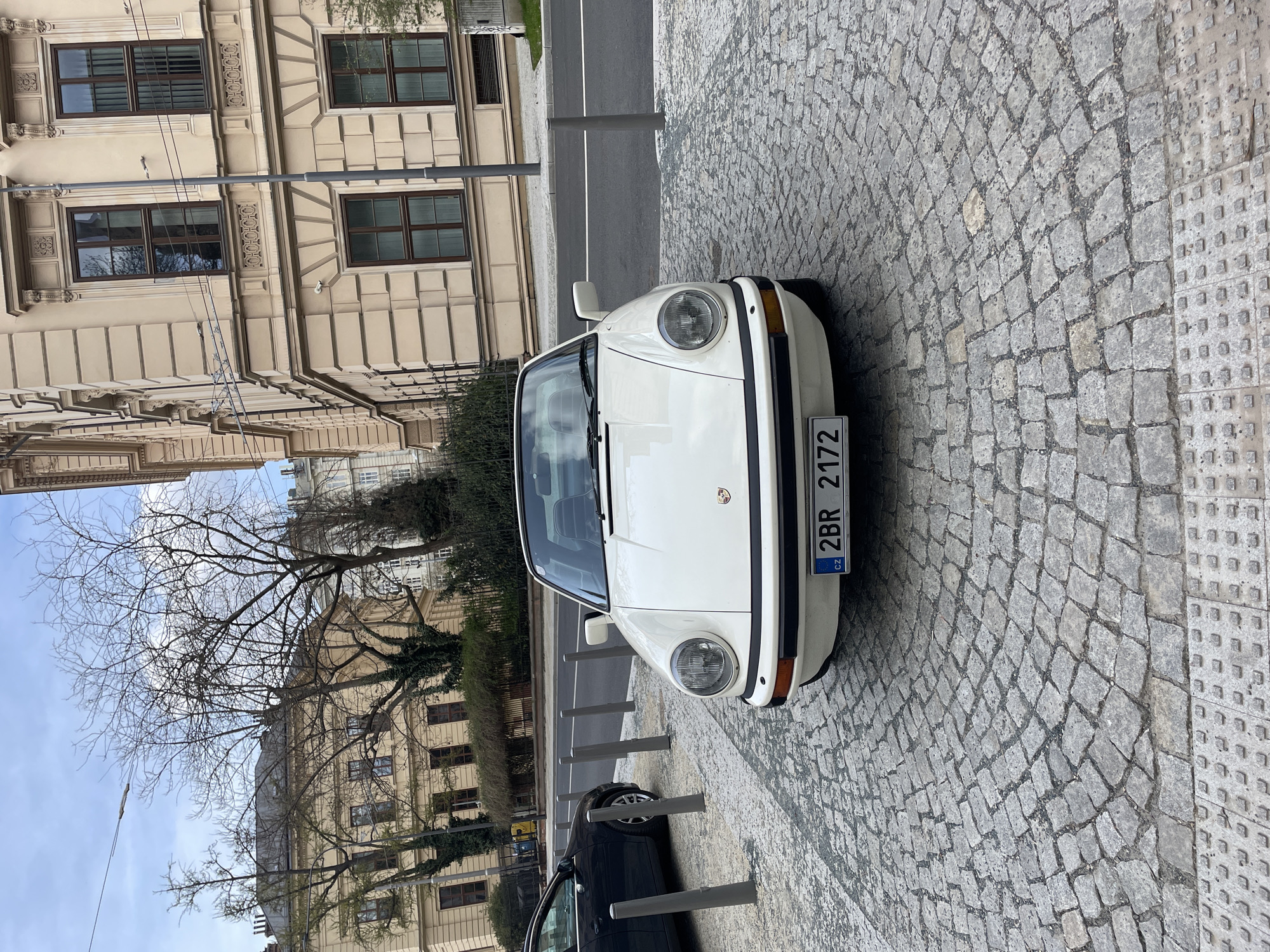 Vintage white Porsche spotted on cobblestone street in Brno