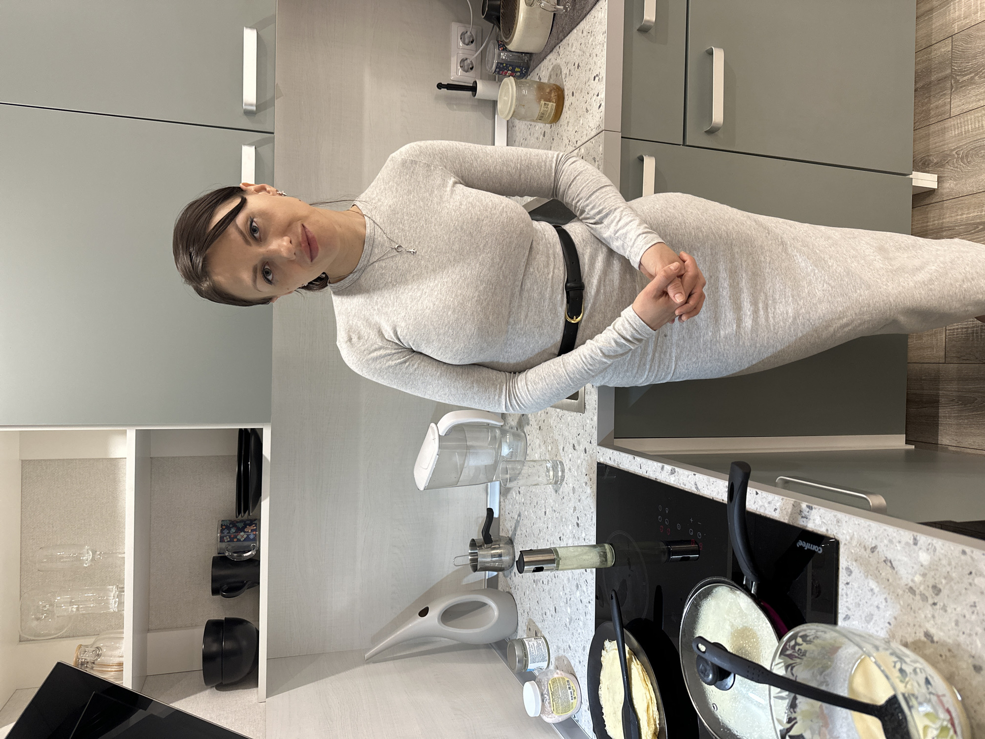 Woman cooks pancakes in kitchen, Murino Russia evening