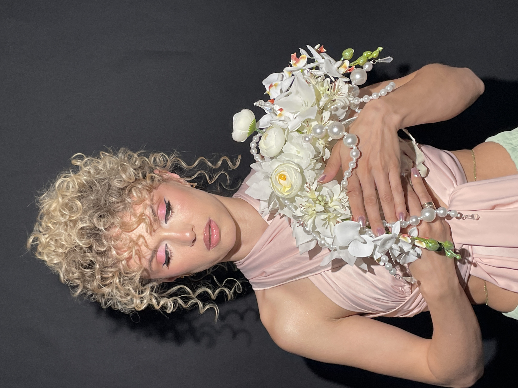 Woman in pink dress poses with flower bouquet in Kazan
