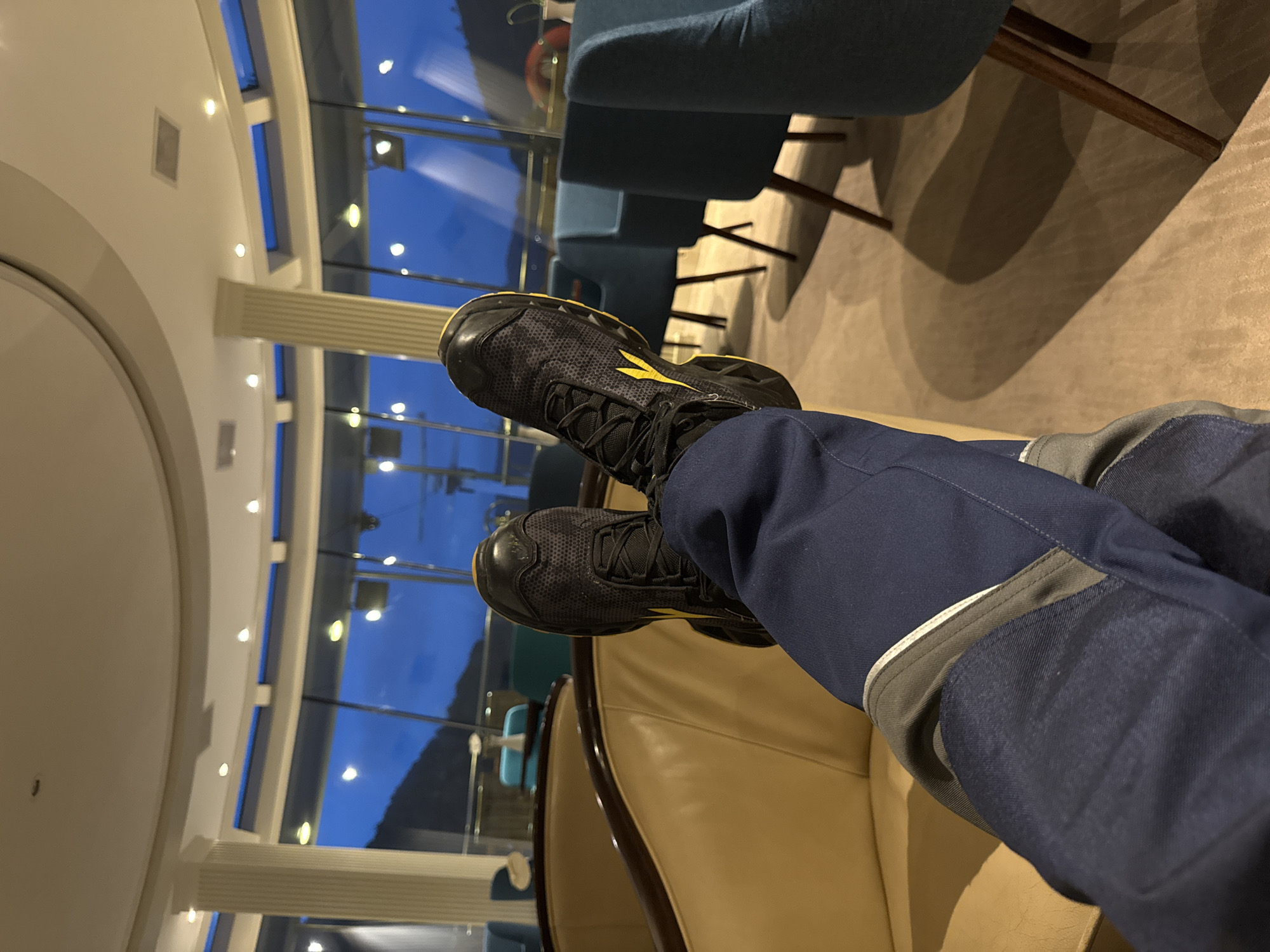 Person relaxing in leather chair wearing athletic shoes