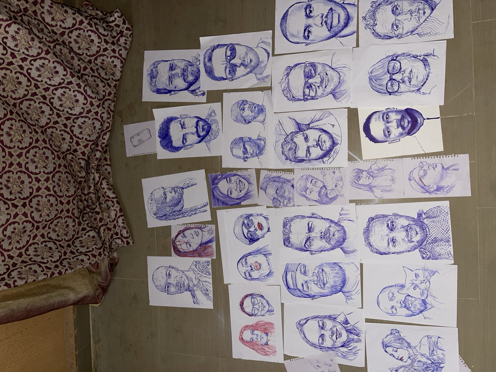 Pen-and-ink portrait collection laid out in Jos, Nigeria