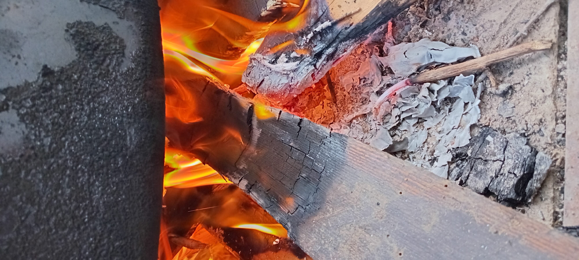 Open fire burning under a large pot outdoors