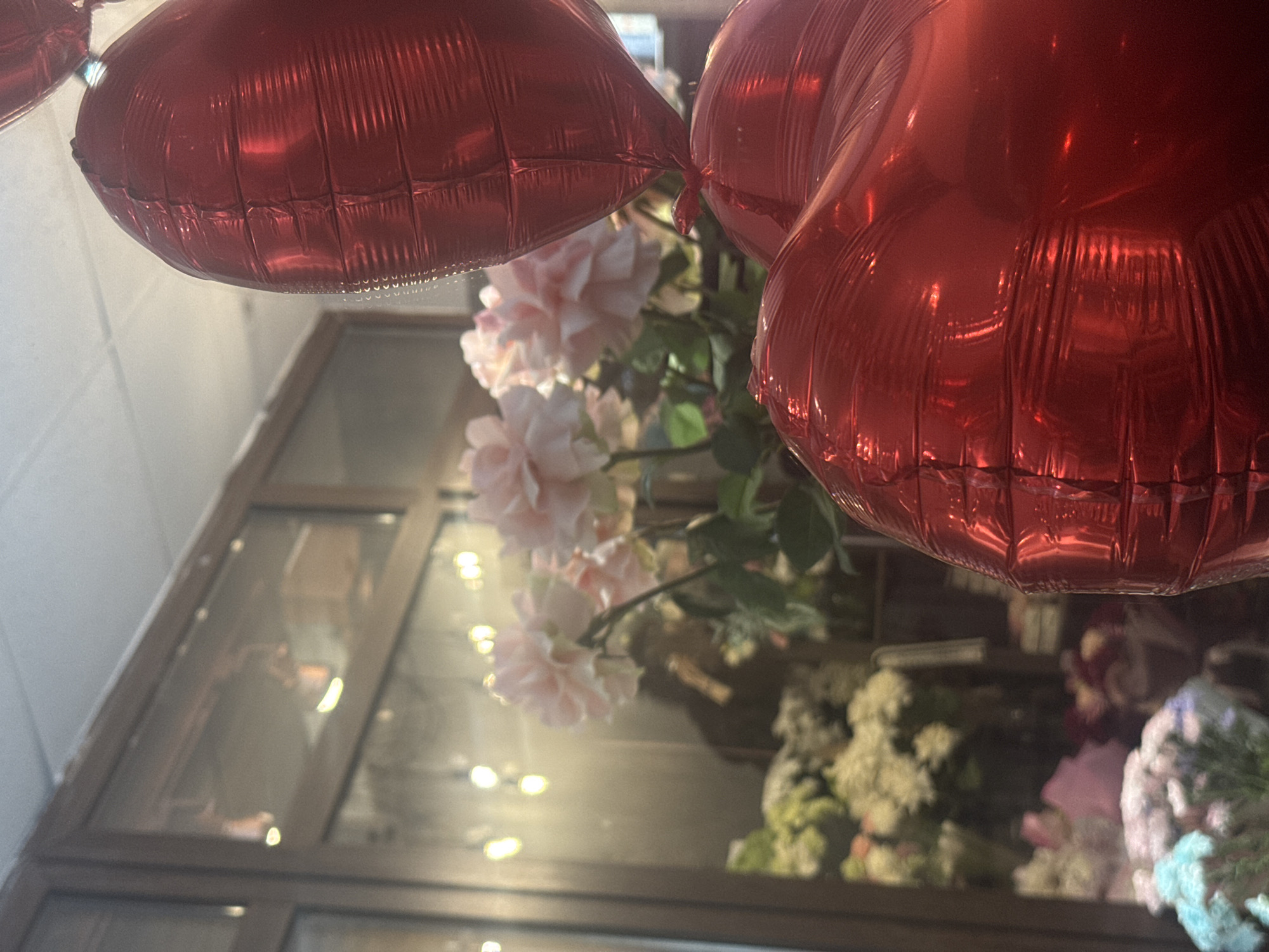 Heart balloons and flowers arranged indoors in Perm