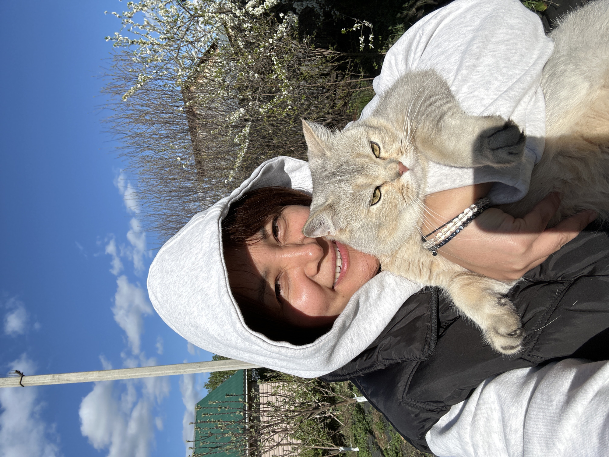 Woman poses with cat in Russian garden setting