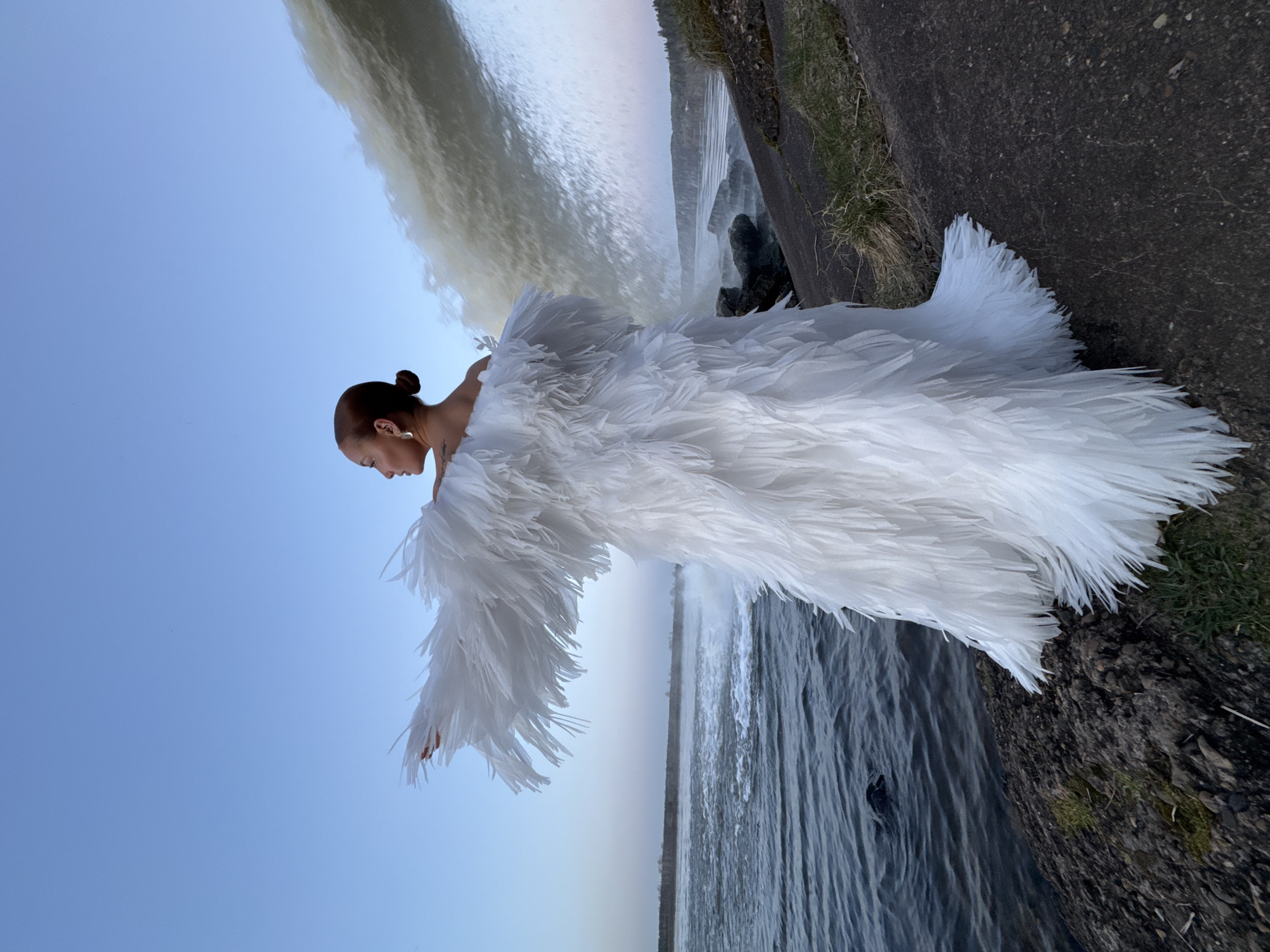 Woman in white feathered dress photographed at Noviy waterfall