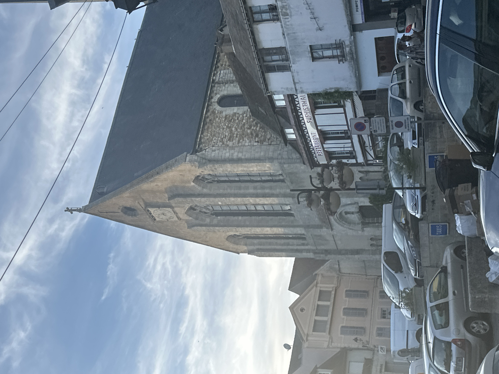 Stone church with clock face anchors a Gallardon street scene