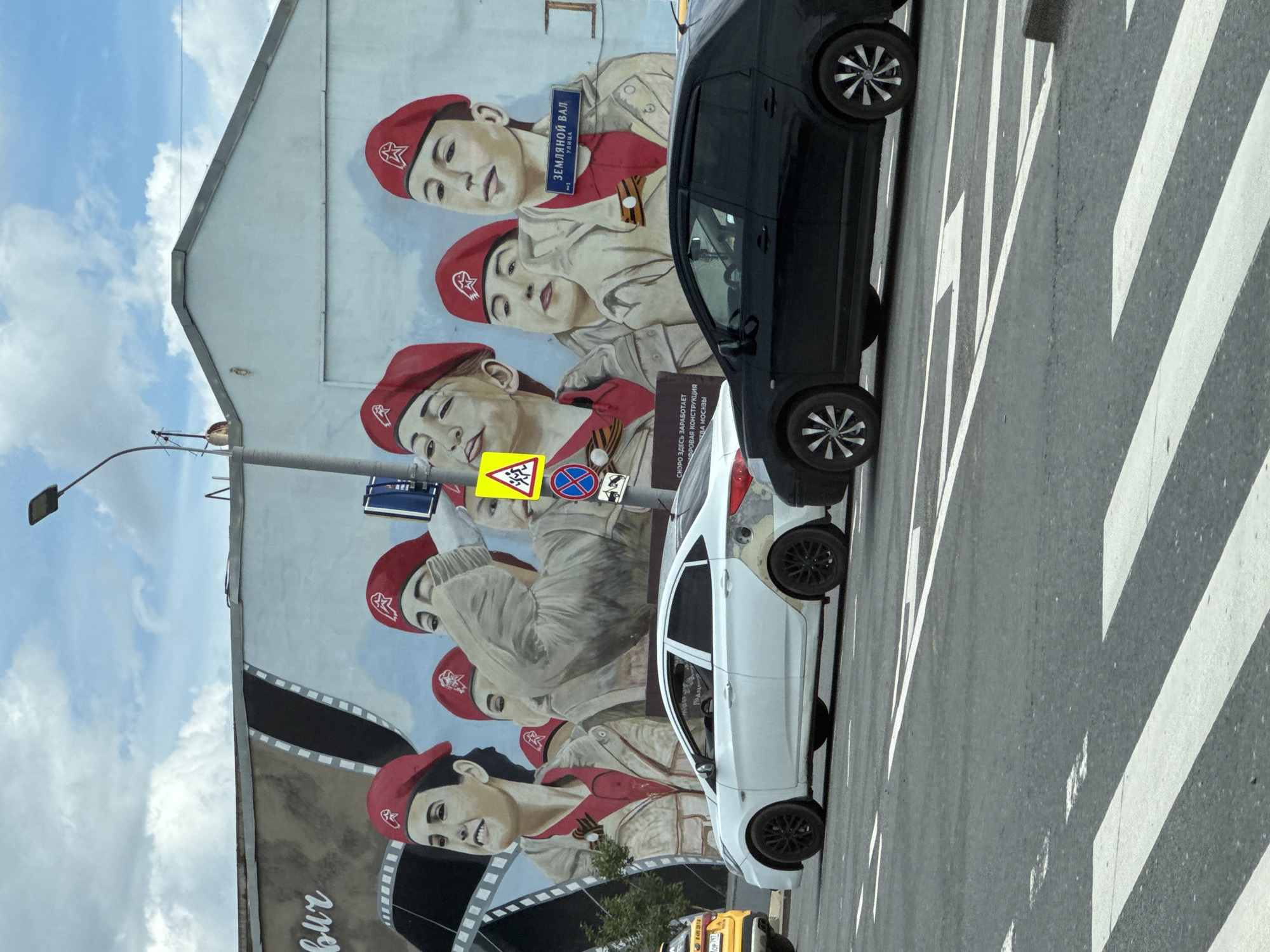 Bold mural of figures in red berets covers a building wall
