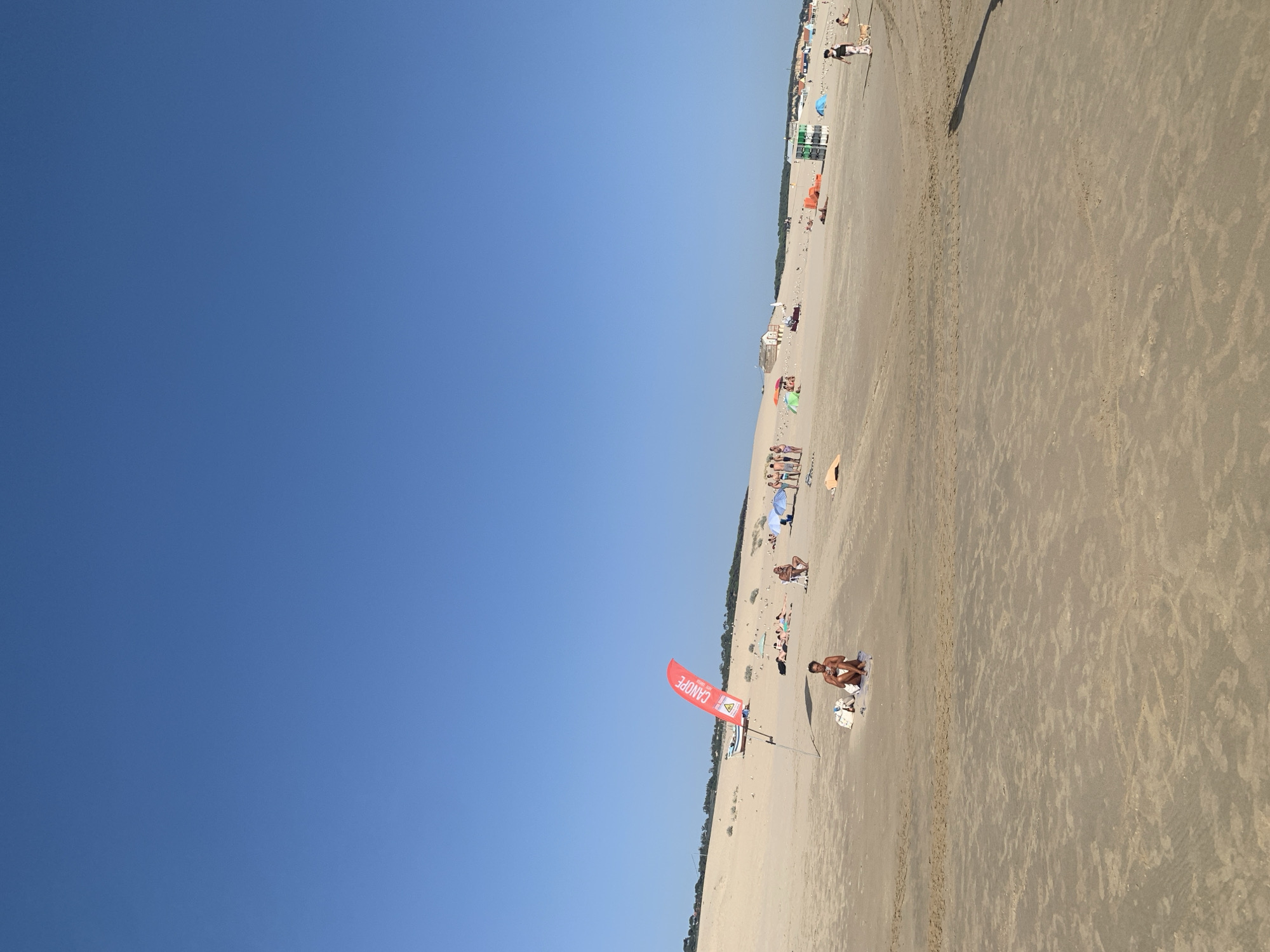 Red tractor on the sand at Costa da Caparica beach