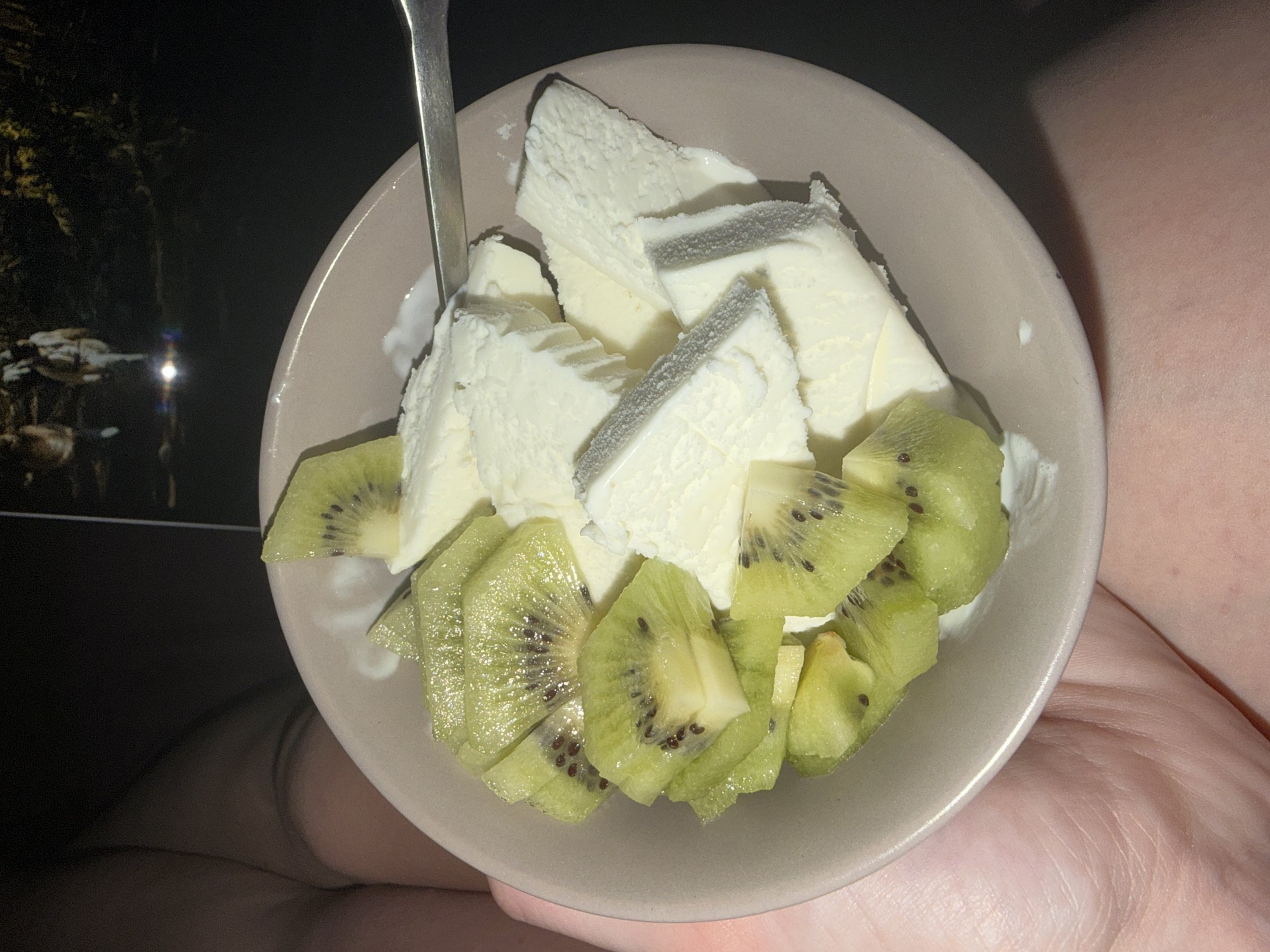 Person enjoys ice cream with kiwi in Novoaleksandrovka