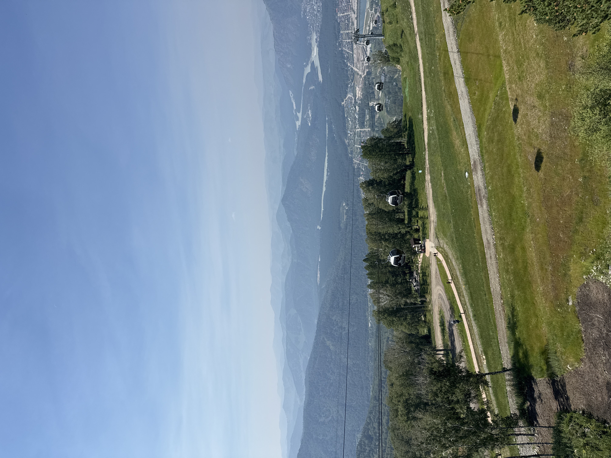 Gondola lift crosses green mountain terrain above Ozernoe, Russia