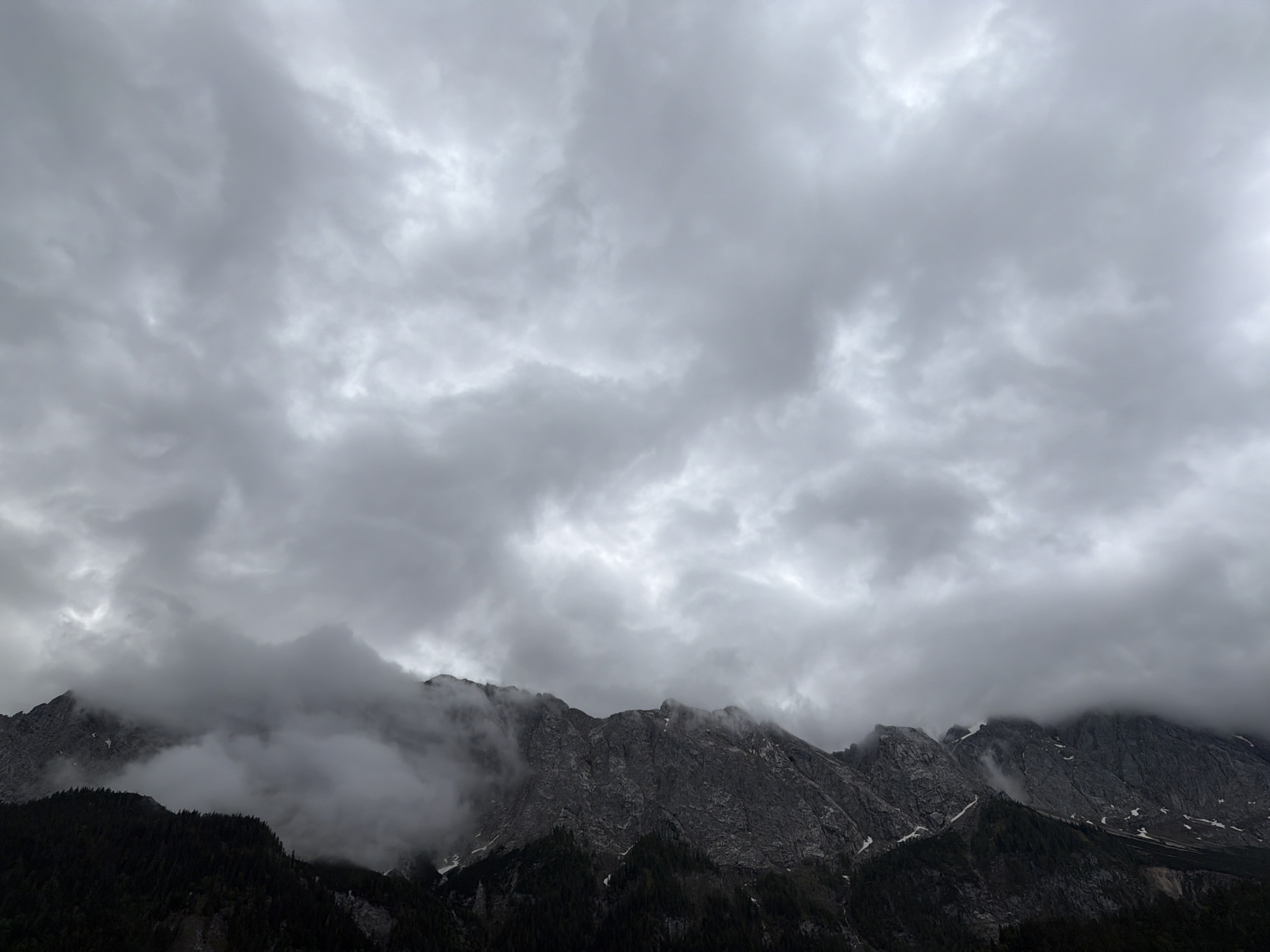 Morning clouds shroud rocky peaks in Grainau, Germany