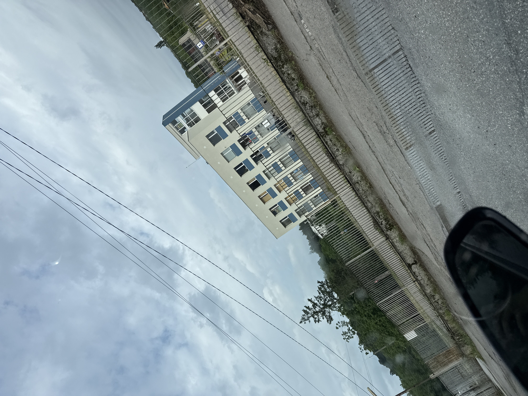 Modern white building with blue accents documented under overcast sky