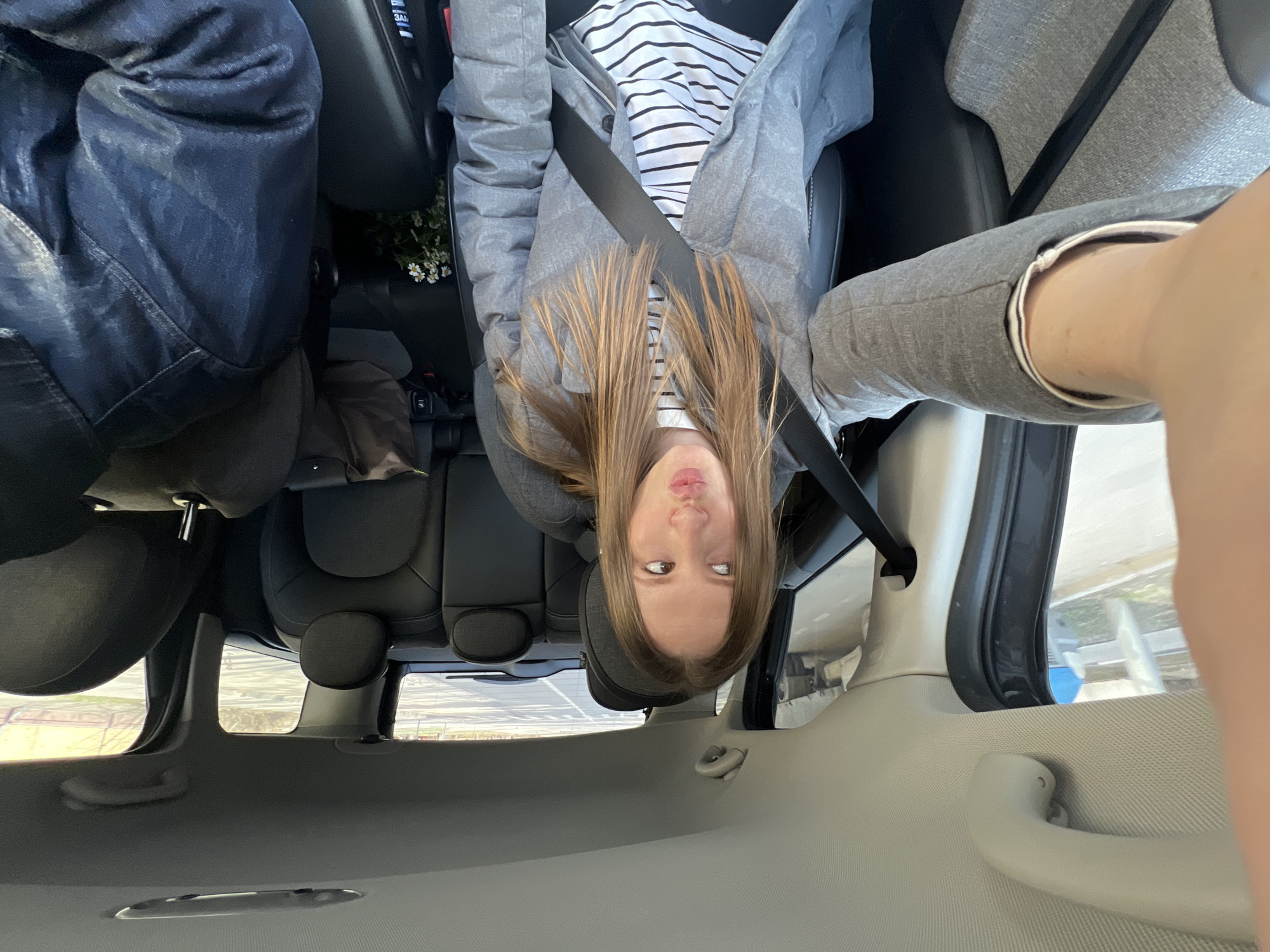 Woman in striped shirt drinks from cup in Moscow car