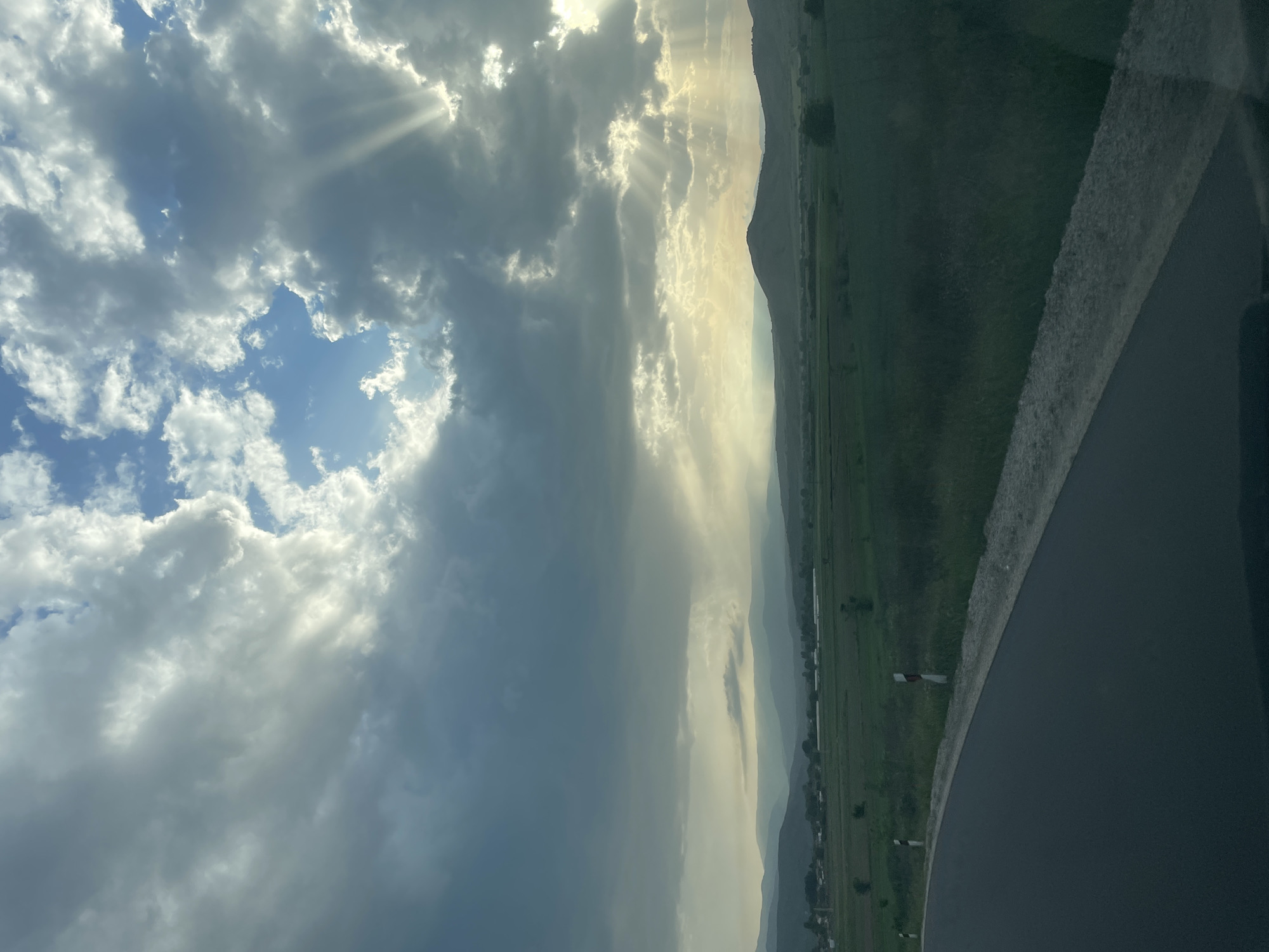 Sunbeams pierce clouds over Isperihovo landscape in Bulgaria
