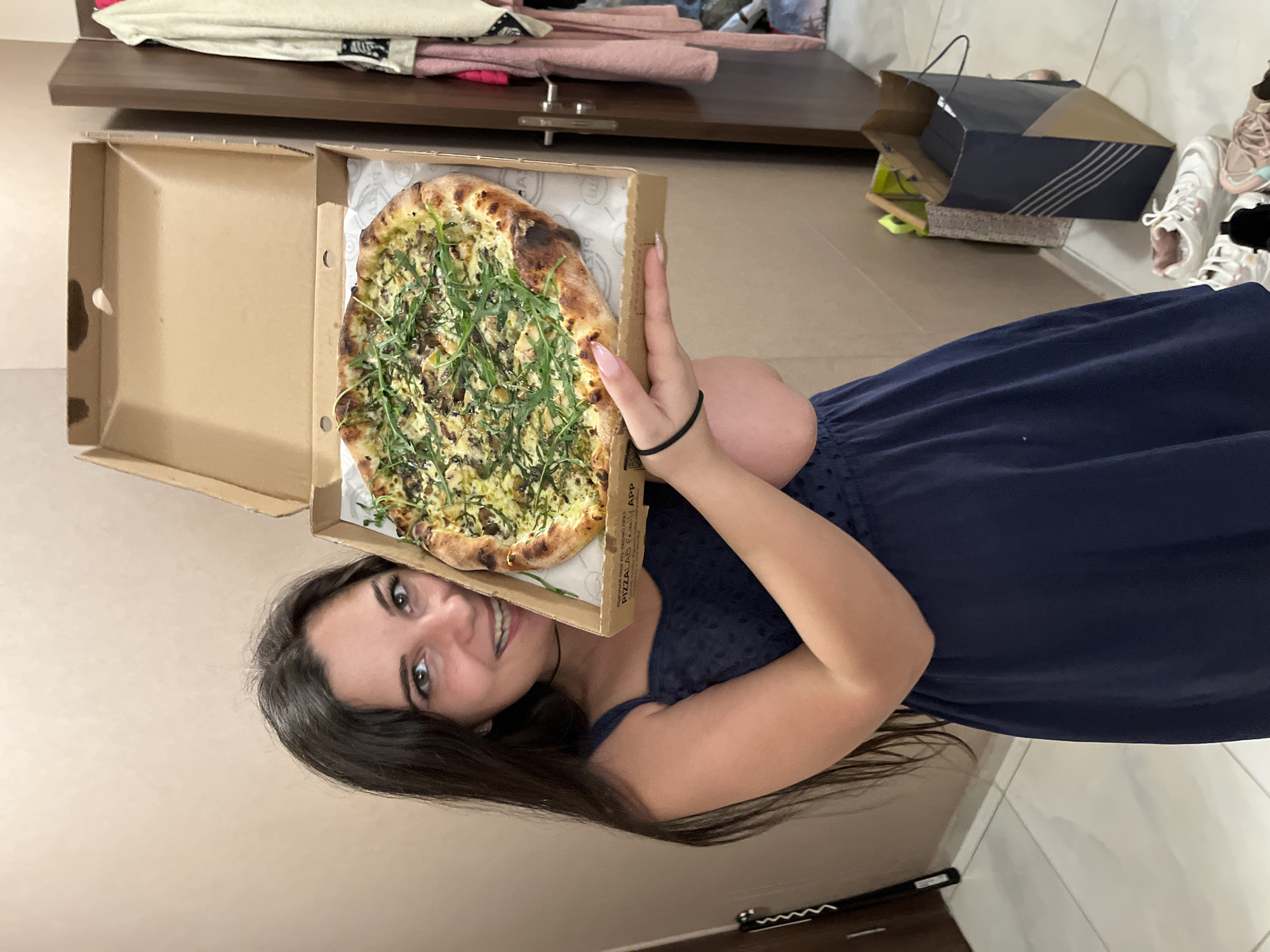 Woman holds pizza with mixed toppings in Sofia