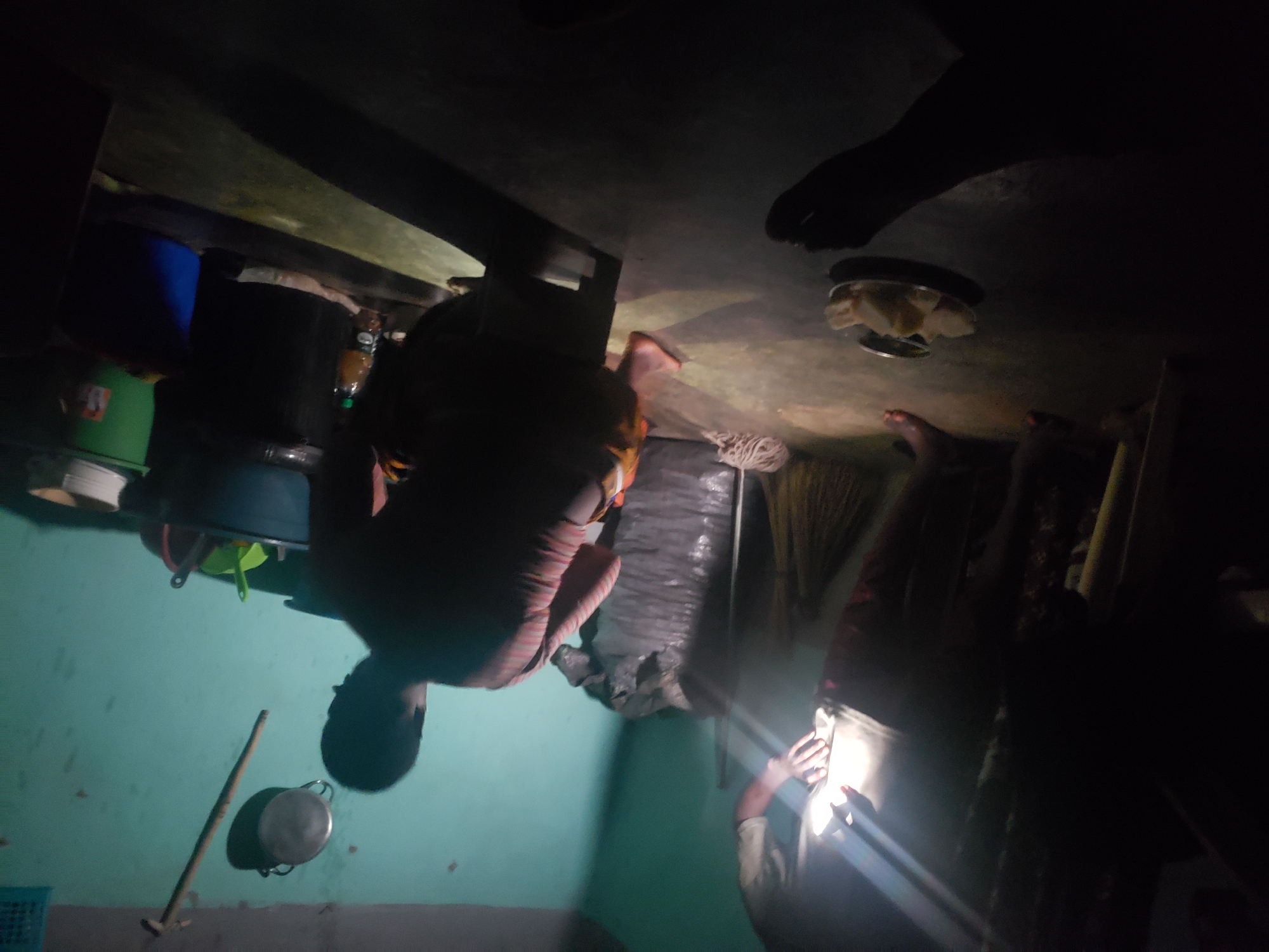 Person uses light source in dim room in Kachia