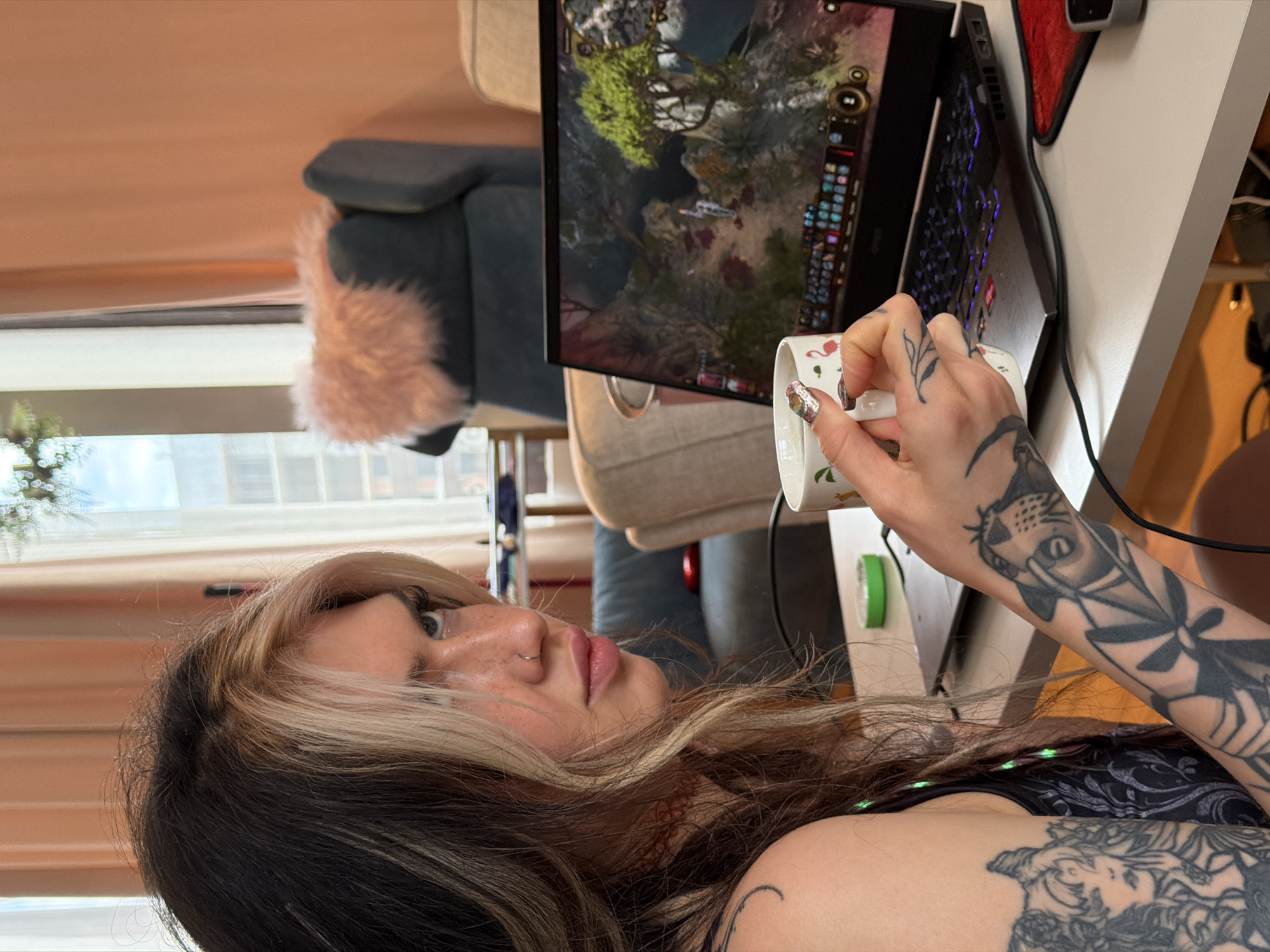 Tattooed gamer enjoys coffee break with flamingo mug in Budva