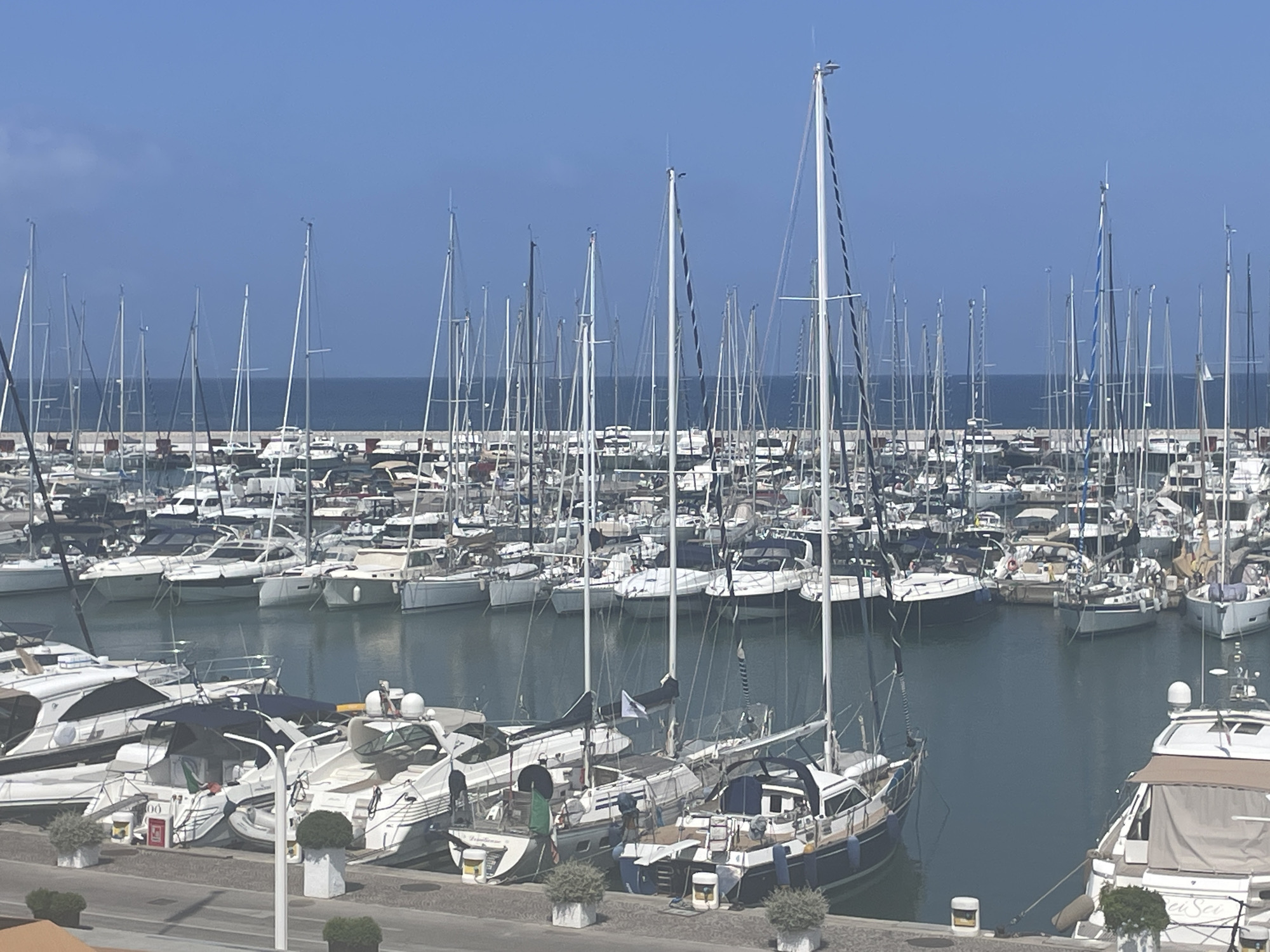 Sailboats and yachts fill Punta Ala's marina on a clear day