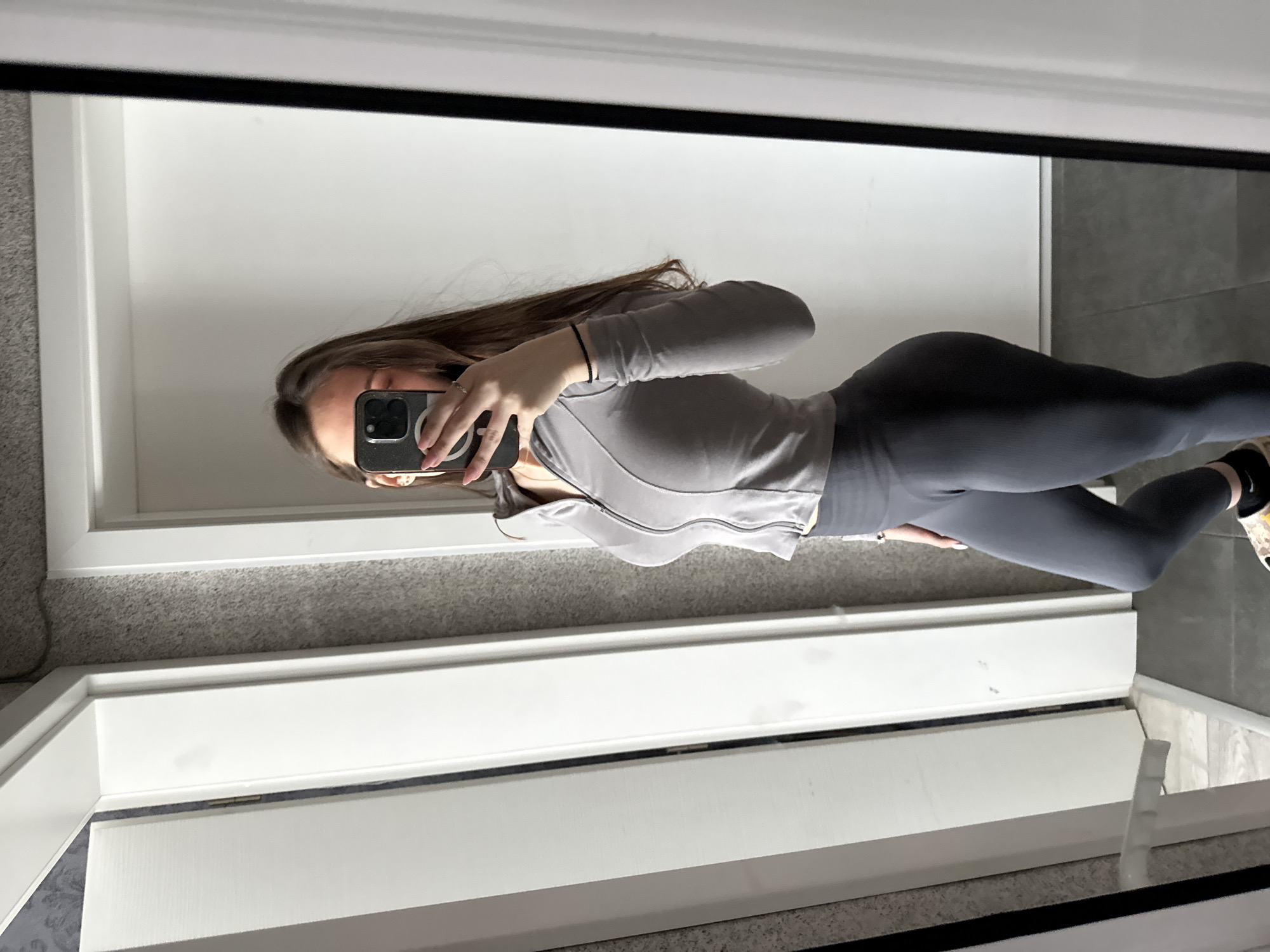 Woman takes mirror selfie in grey athletic wear, Sofia