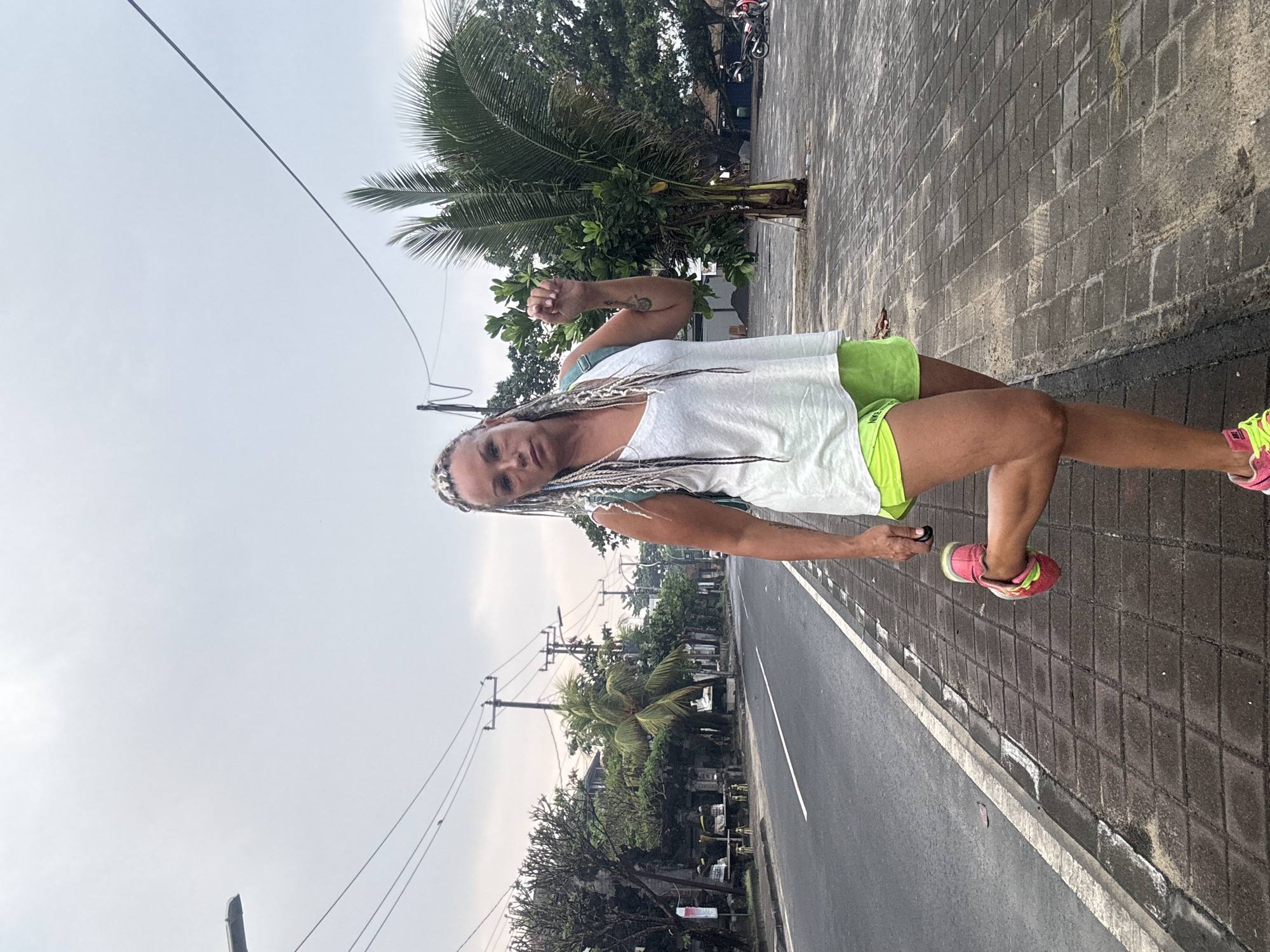 Woman observed on wet Kuta sidewalk during evening hours