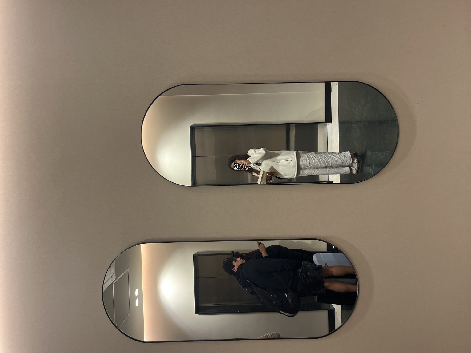 Person takes selfie with phone using decorative mirrors indoors