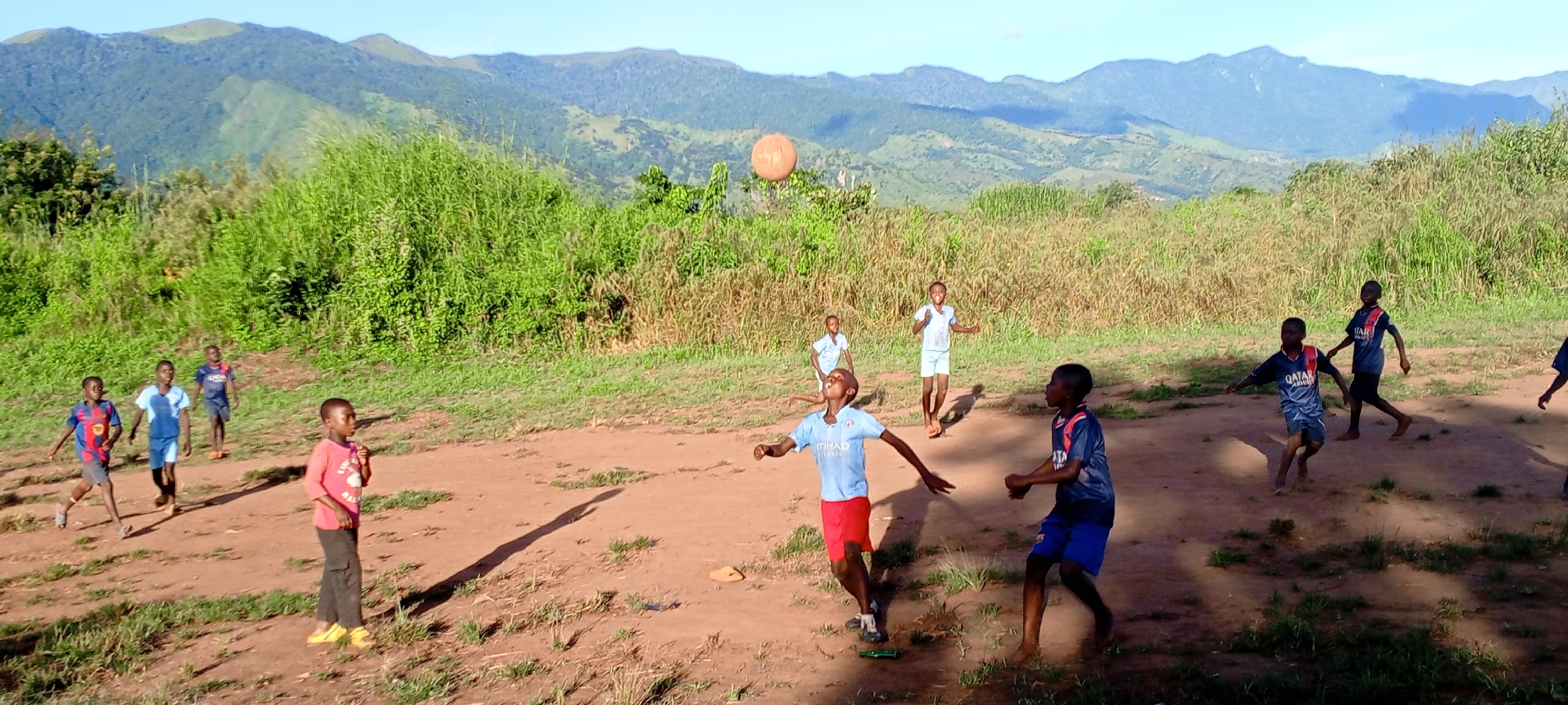 Children play ball on dirt field in Ngalula