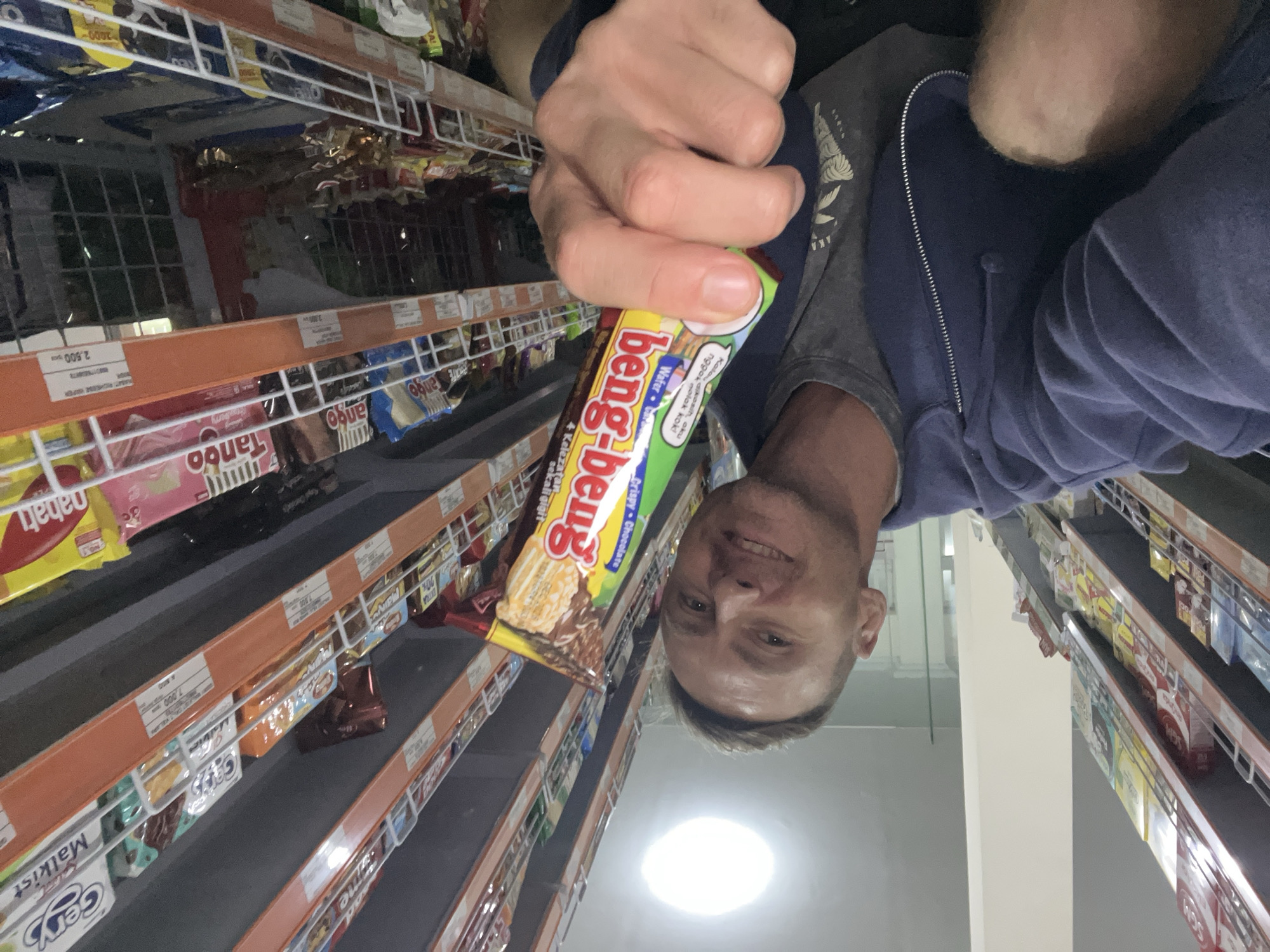Man shops for snacks, takes selfie in Sukawati grocery store