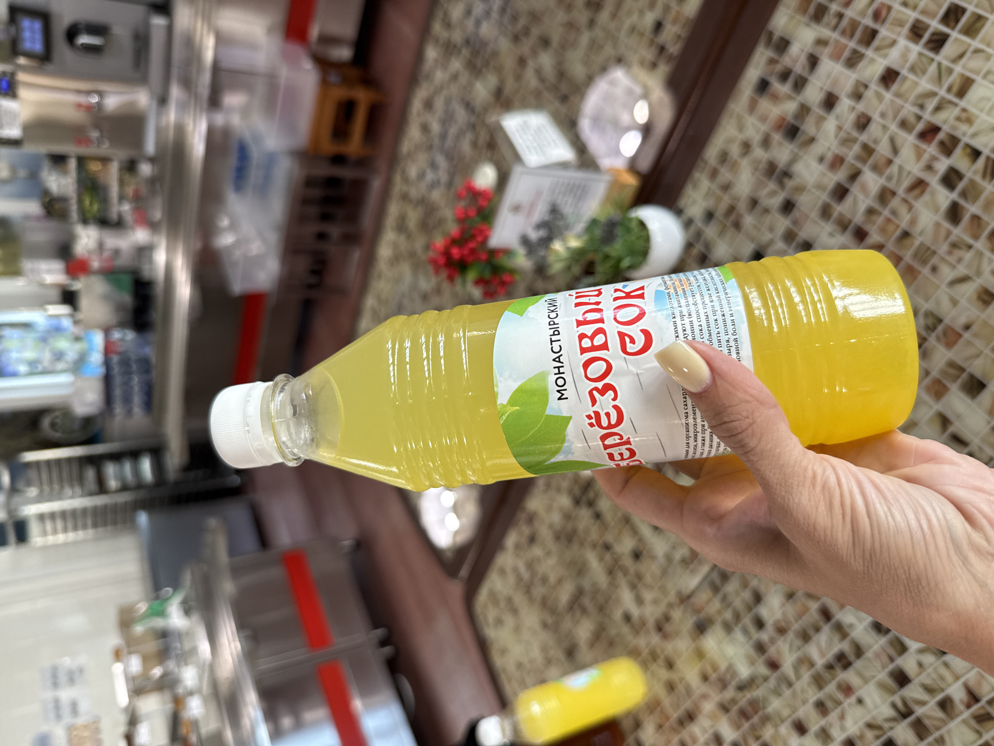 Person holds yellow liquid bottle in close-up photograph