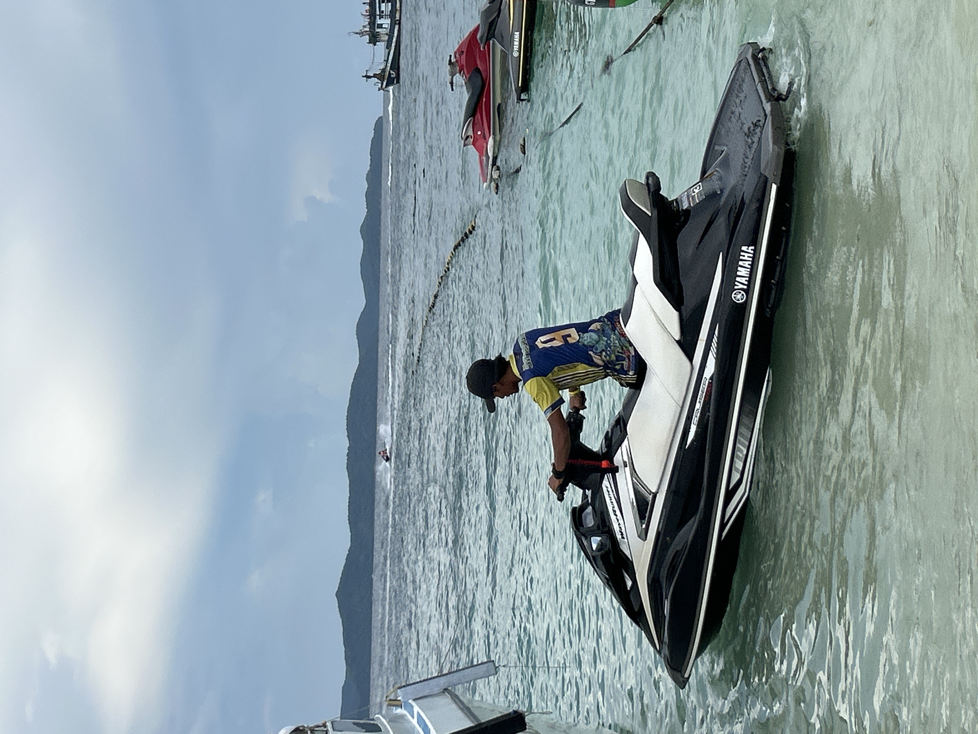 Crowded beach morning in Phru Nai with boats, jet skis, and water activity