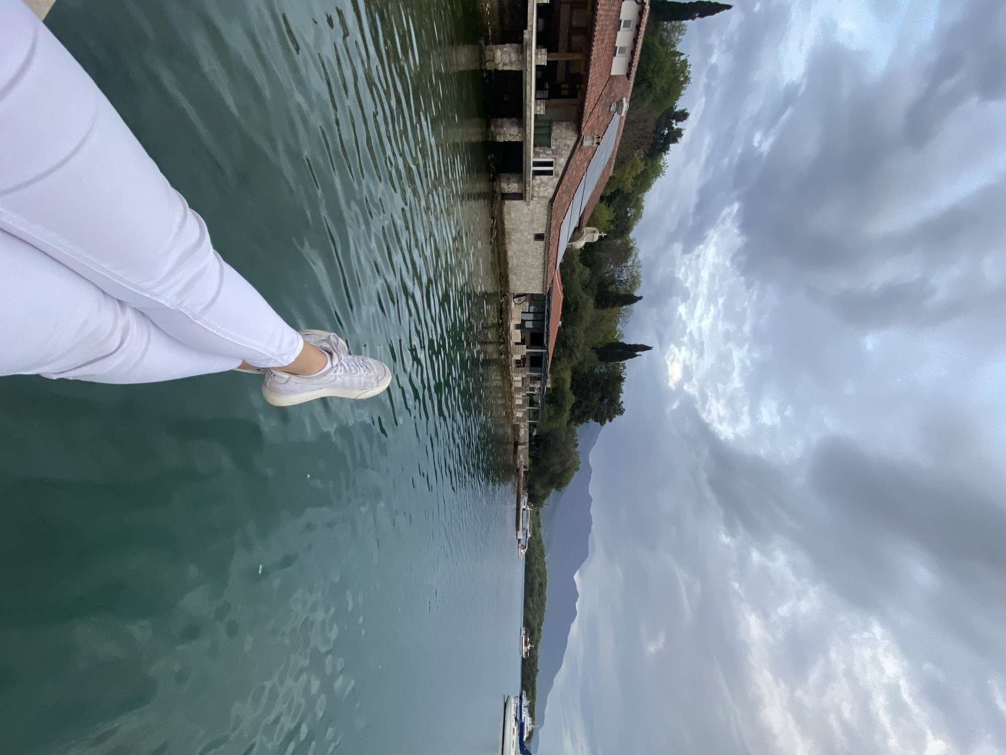 Person dangles feet over water in Montenegro lakeside moment