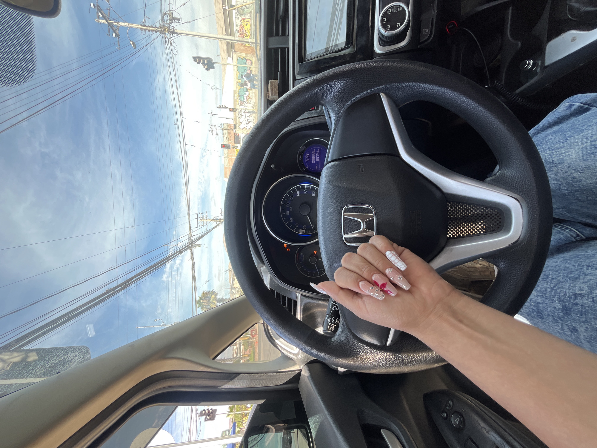 Driver with decorated nails tends to manicure in Honda