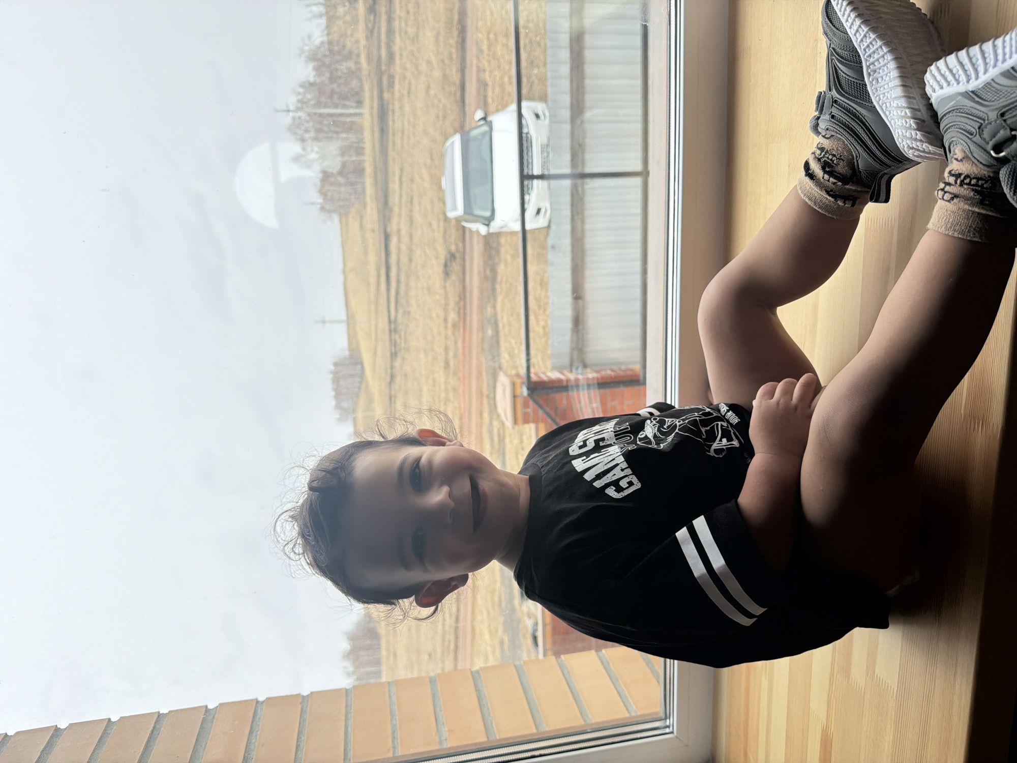 Child sits on windowsill in Krasnoyarsk wearing gaming shirt