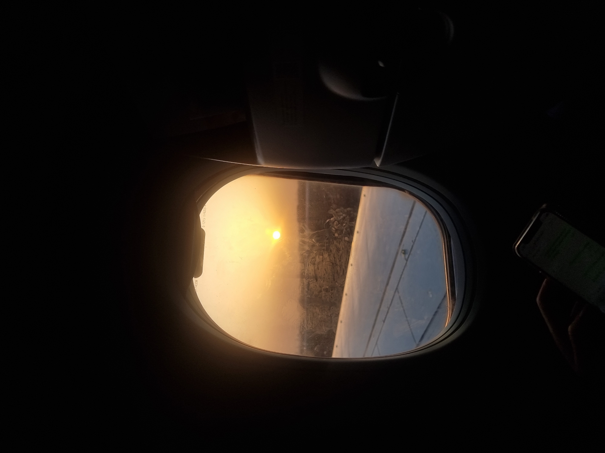 Passenger captures sunset view through airplane window near Paris
